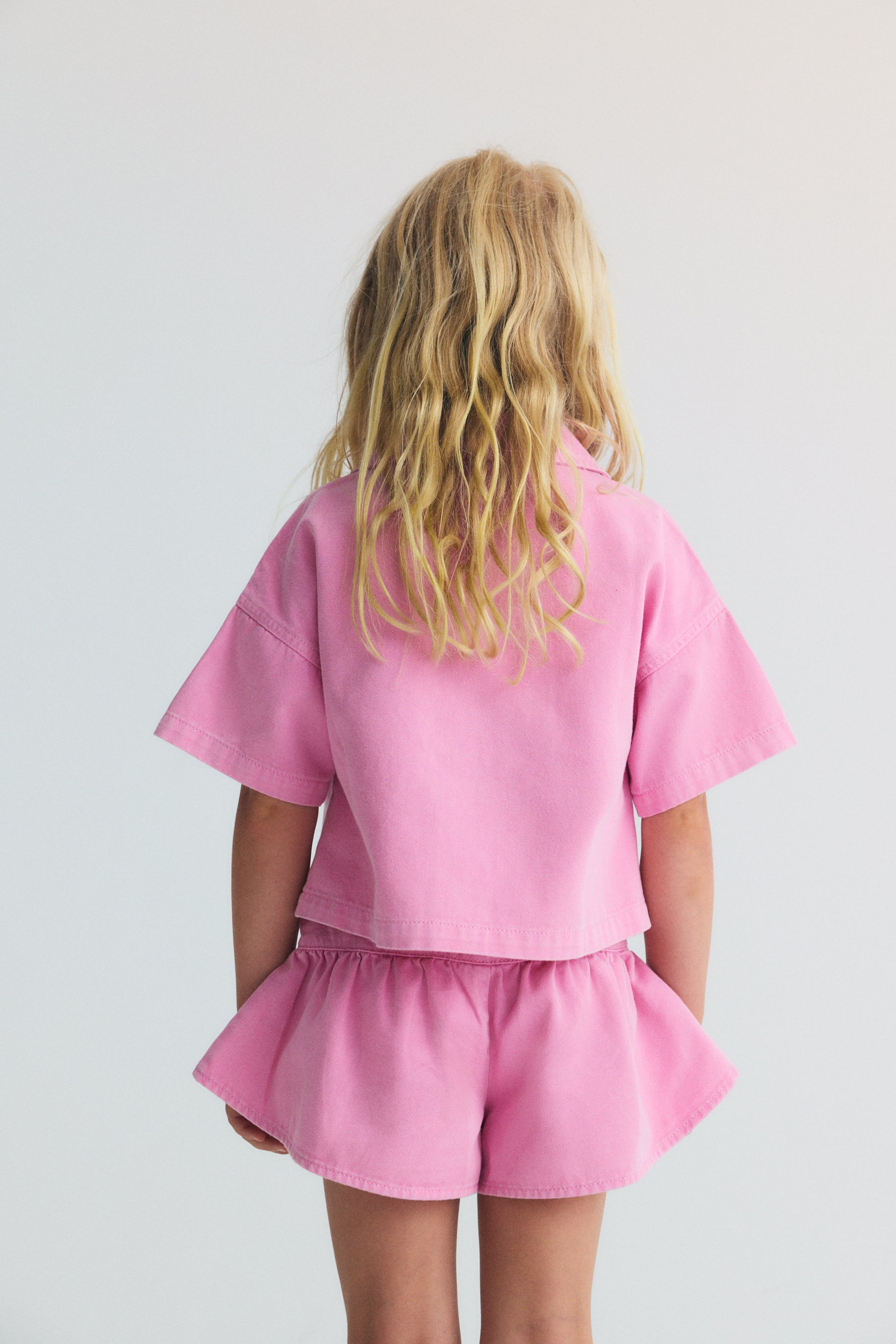 Washed denim shorts with a pointed cut and voluminous leg, featuring delicate ruching for a fresh and playful silhouette.