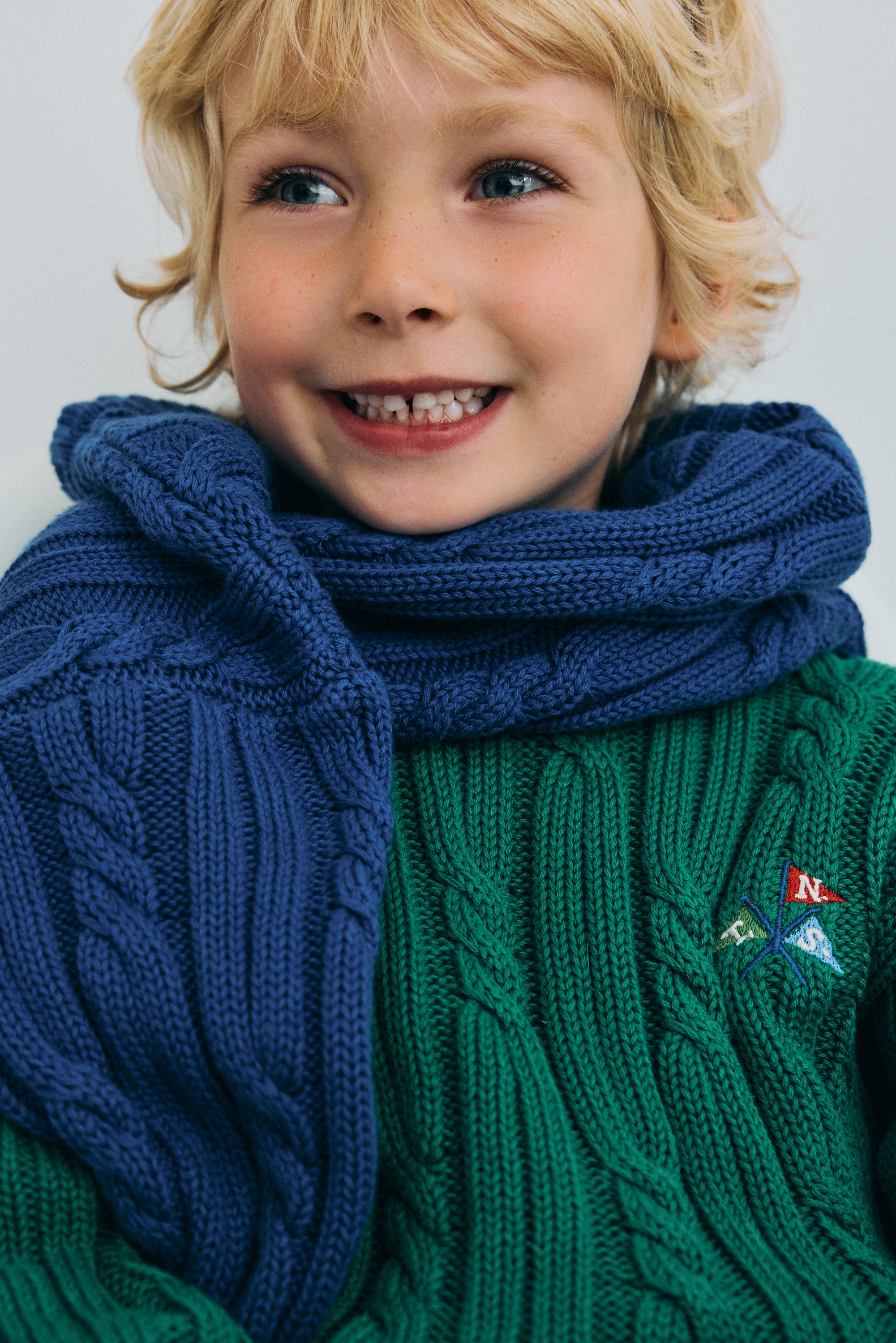 Cable knit sweater with ribbed trims and a playful branded embroidery featuring a flag motif for a subtle, stylish detail.