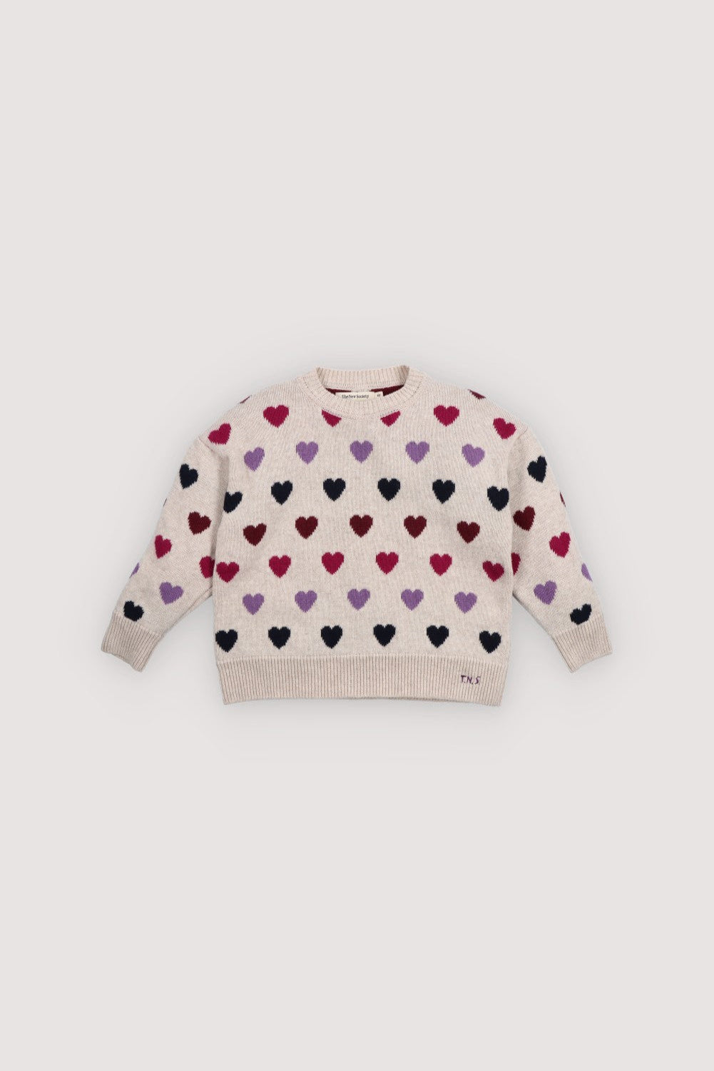 Knitted sweater with colorful heart pattern on a light background. The New Society kids collection AW25
