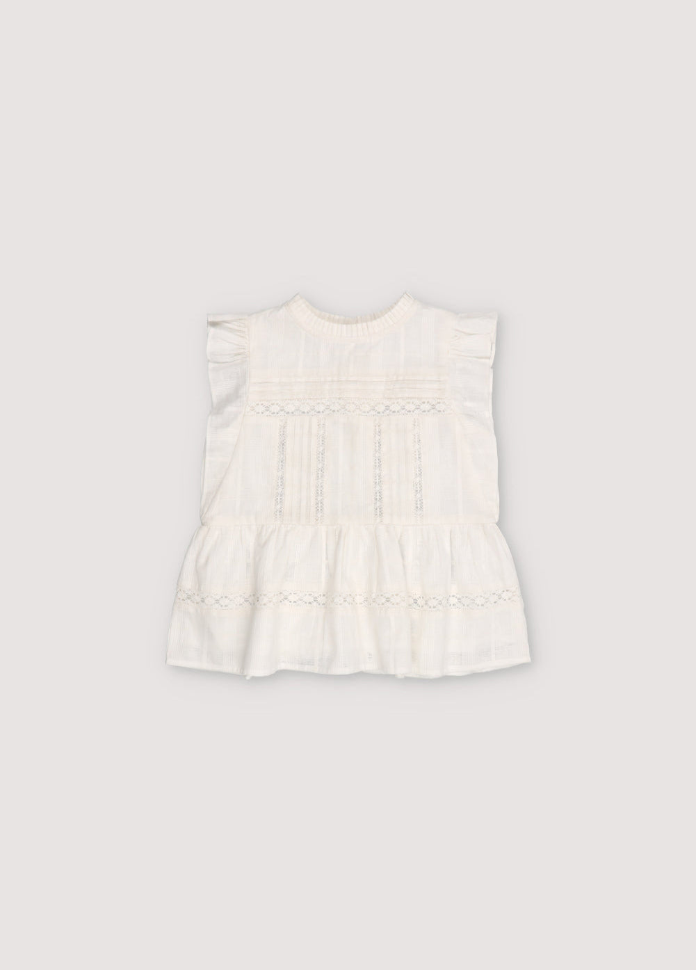 Blouse with jacquard fabric and lace details. It features ruffles on the sleeves and an opening at the back with mother-of-pearl buttons.