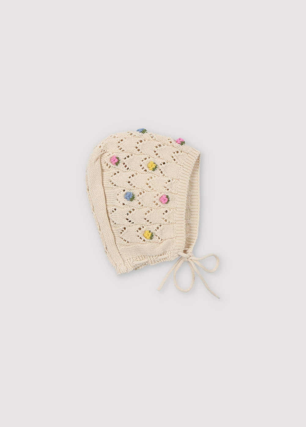 Knit baby hat with structure and flower details. It has two ties of the same yarn to tie