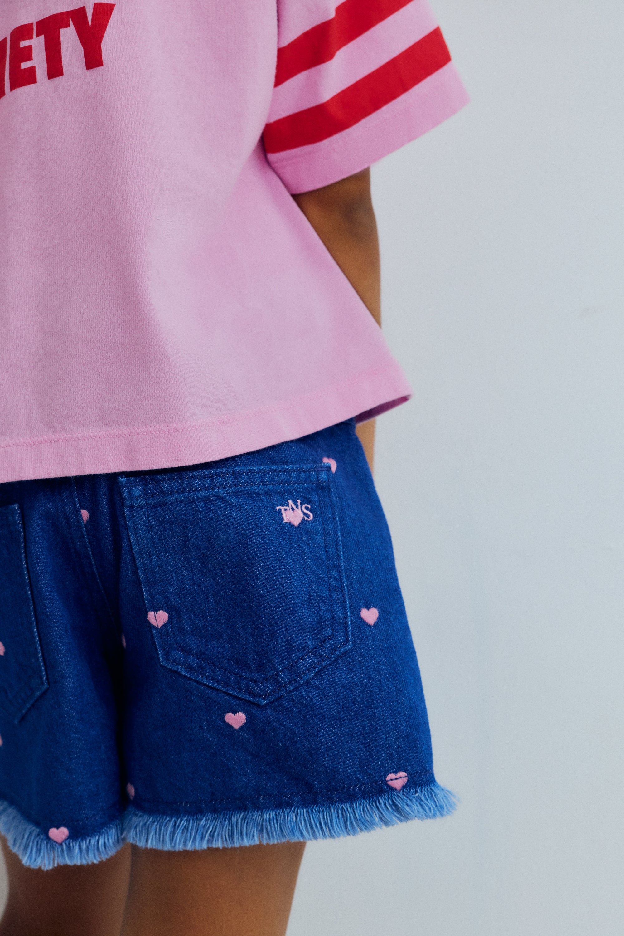 Crop style t-shirt in soft cotton, featuring contrasting branded embroidery, a stripe print on the sleeve, and a collection print on the back for a playful, modern look.