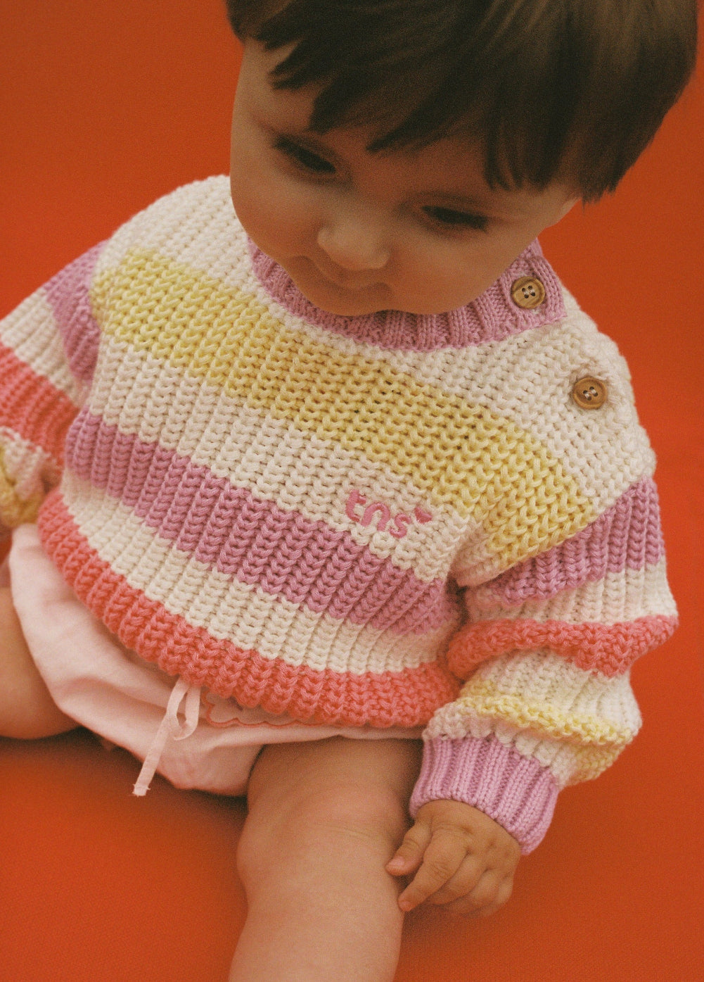 Baby striped cotton knit featuring fresh, summery colors and a charming embroidered logo detail on the chest