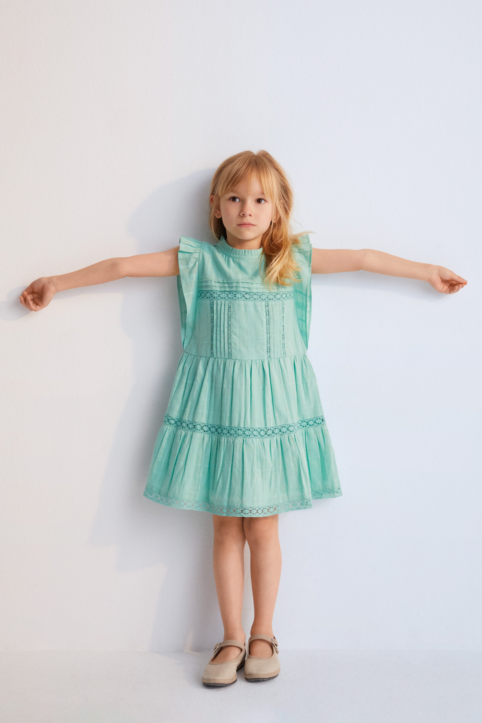 Robe courte en tissu jacquard et détails en dentelle. Il présente des volants sur les manches et une ouverture au dos avec bouton en nacre.