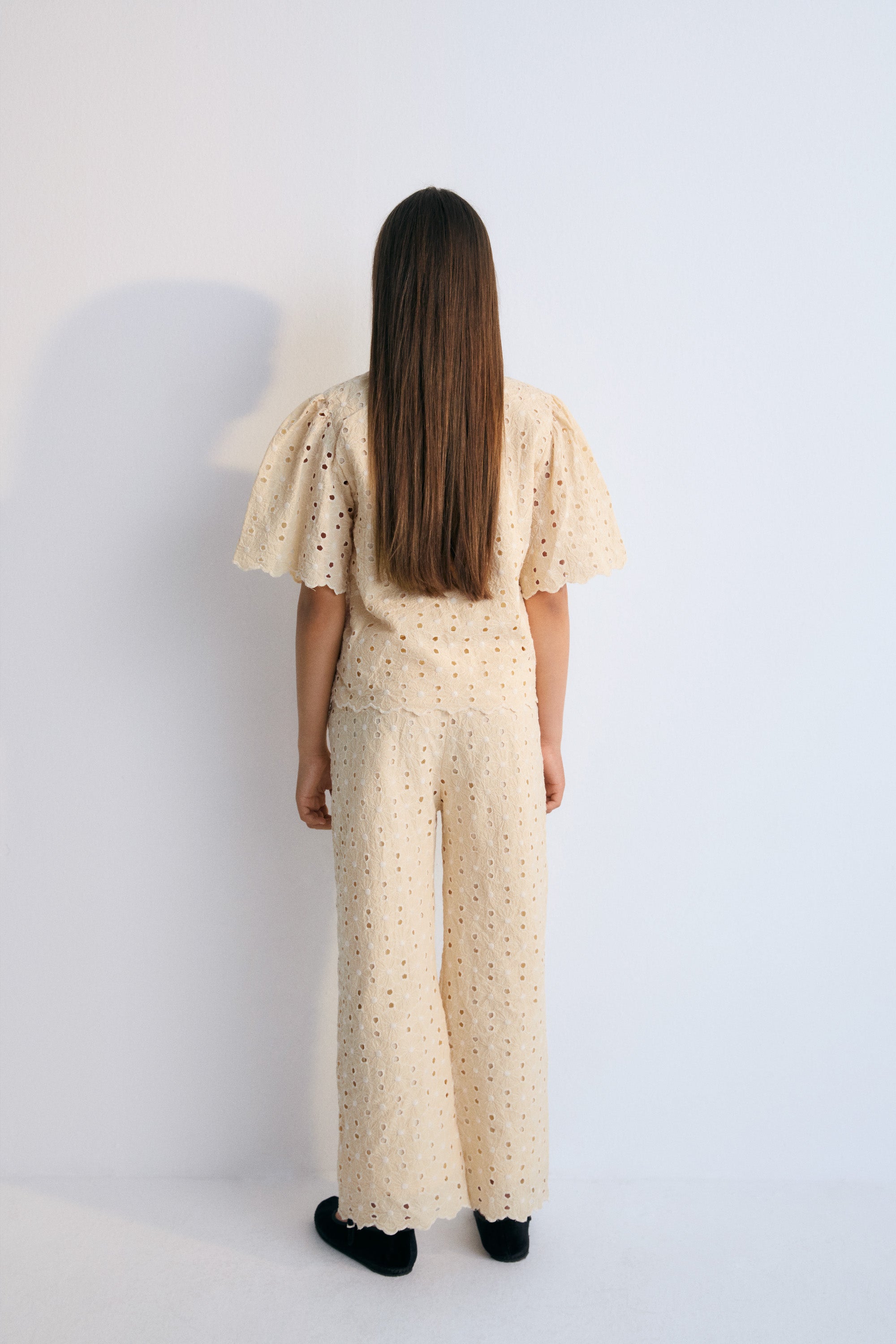 Creta Blouse in embroidered blend cotton fabric in macadamia color, featuring gathered sleeves, a high neckline, and central bow closure. New Collection Kids