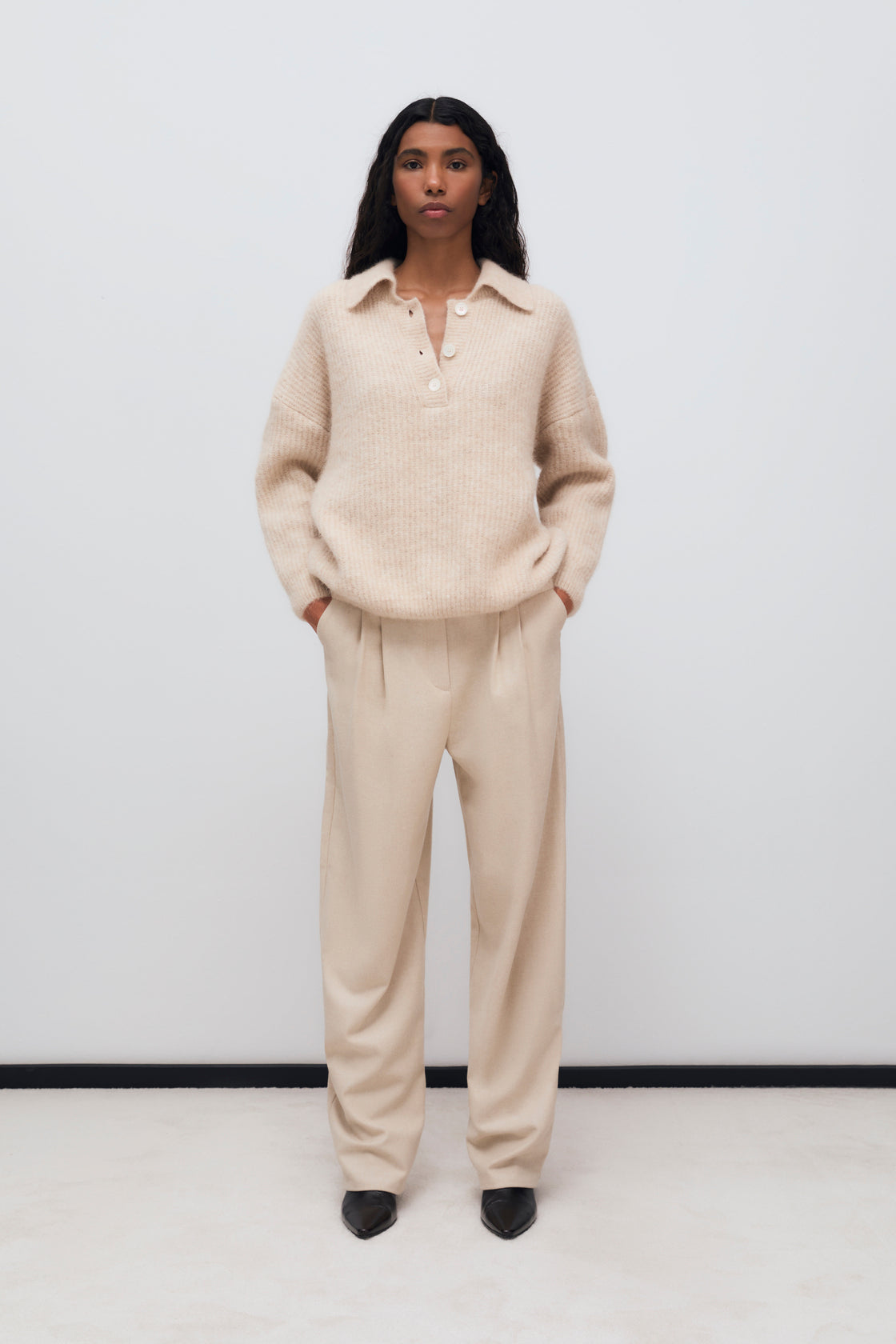 Wool pant with pleat detail in the front and side pockets. They feature a waistband with a hidden button closure.