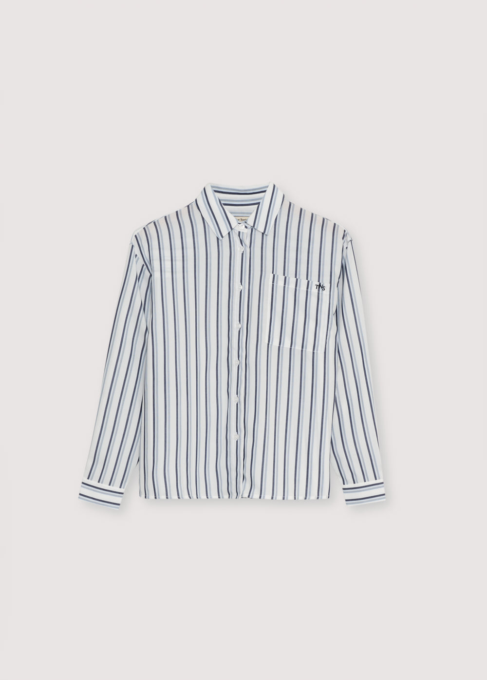 Tencel striped shirt in bluish tones with cuffs and button opening in the same tone. It features a patch pocket on the front I t has a matching scarf in the same quality.