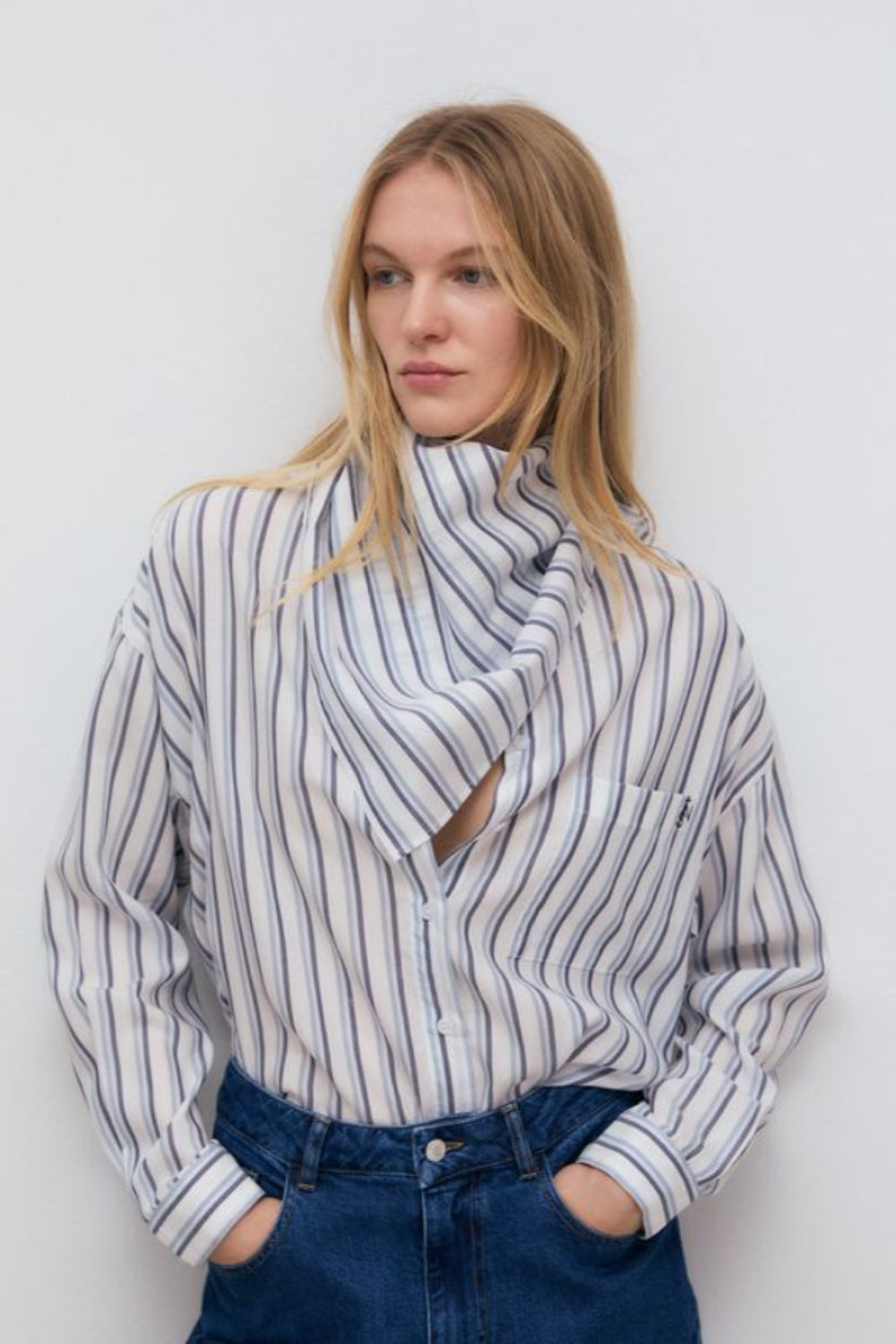 Tencel striped shirt in bluish tones with cuffs and button opening in the same tone. It features a patch pocket on the front I t has a matching scarf in the same quality.