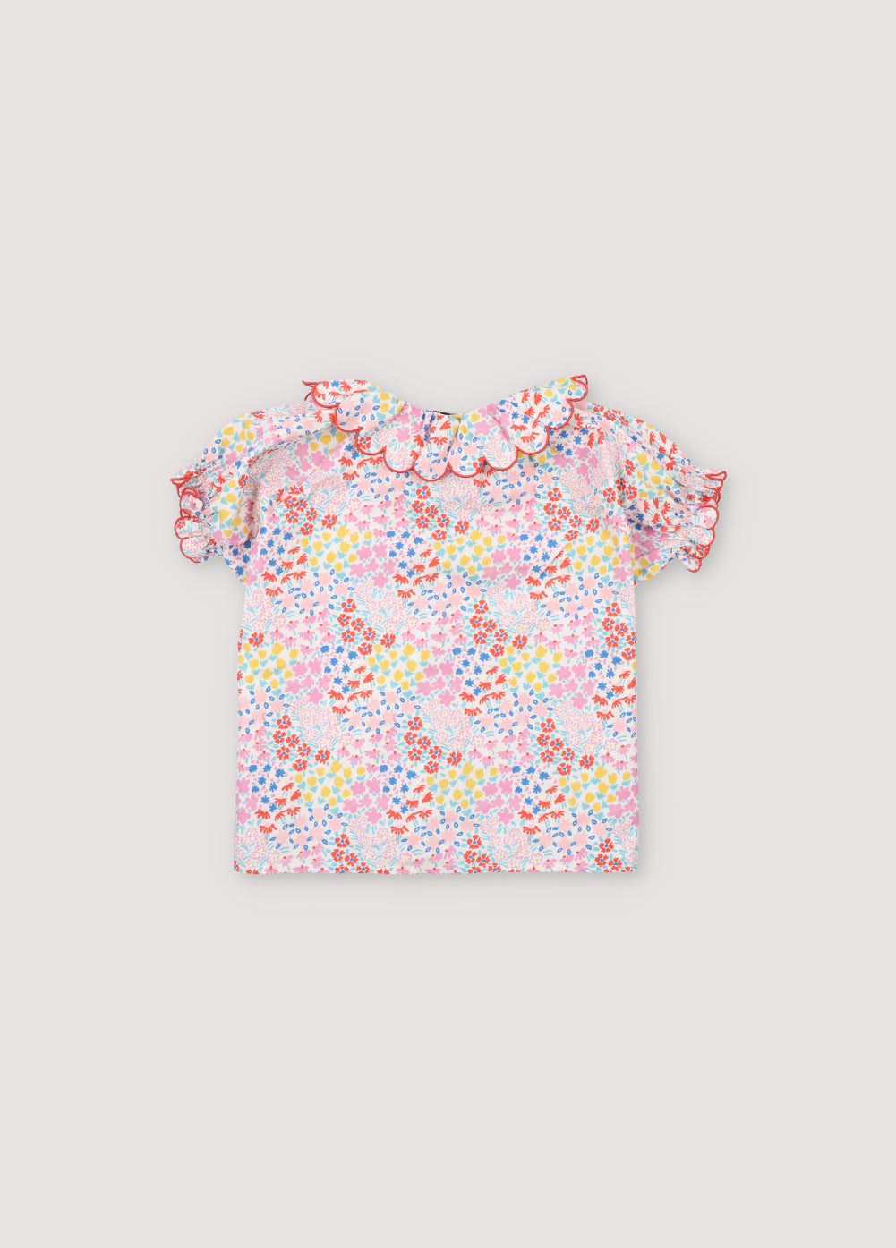 Greneva Blouse in 100% cotton voile with our anemone print. Short-sleeved blouse with a ruffle, gathered neckline with embroidery, and open neckline with button closure. The New Society