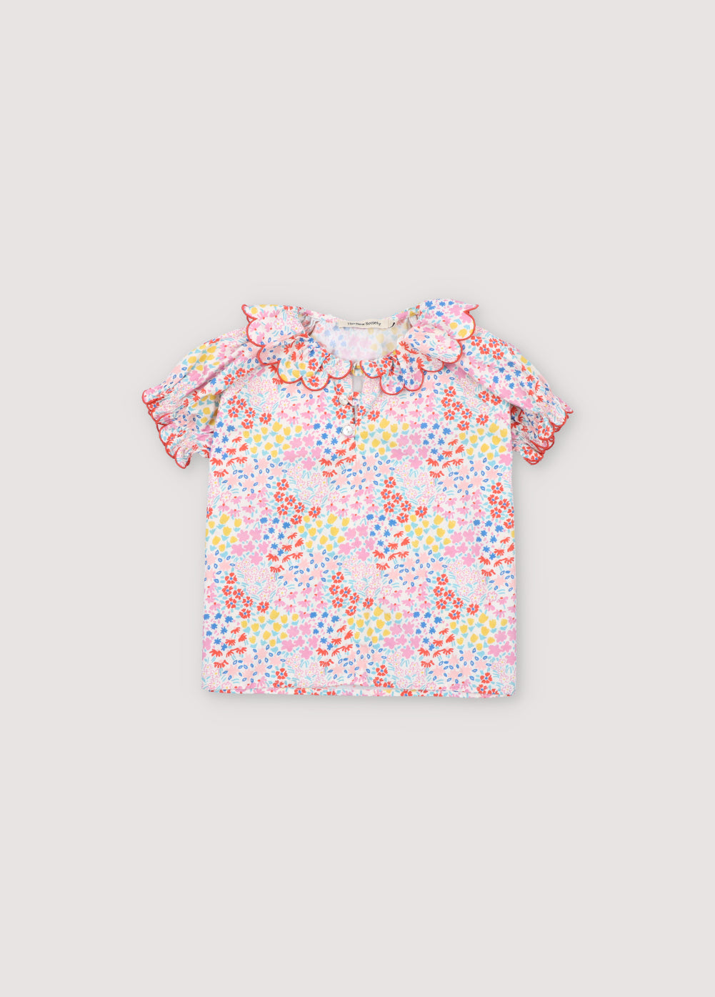 Greneva Blouse in 100% cotton voile with our anemone print. Short-sleeved blouse with a ruffle, gathered neckline with embroidery, and open neckline with button closure. Kids Collection. The New Society