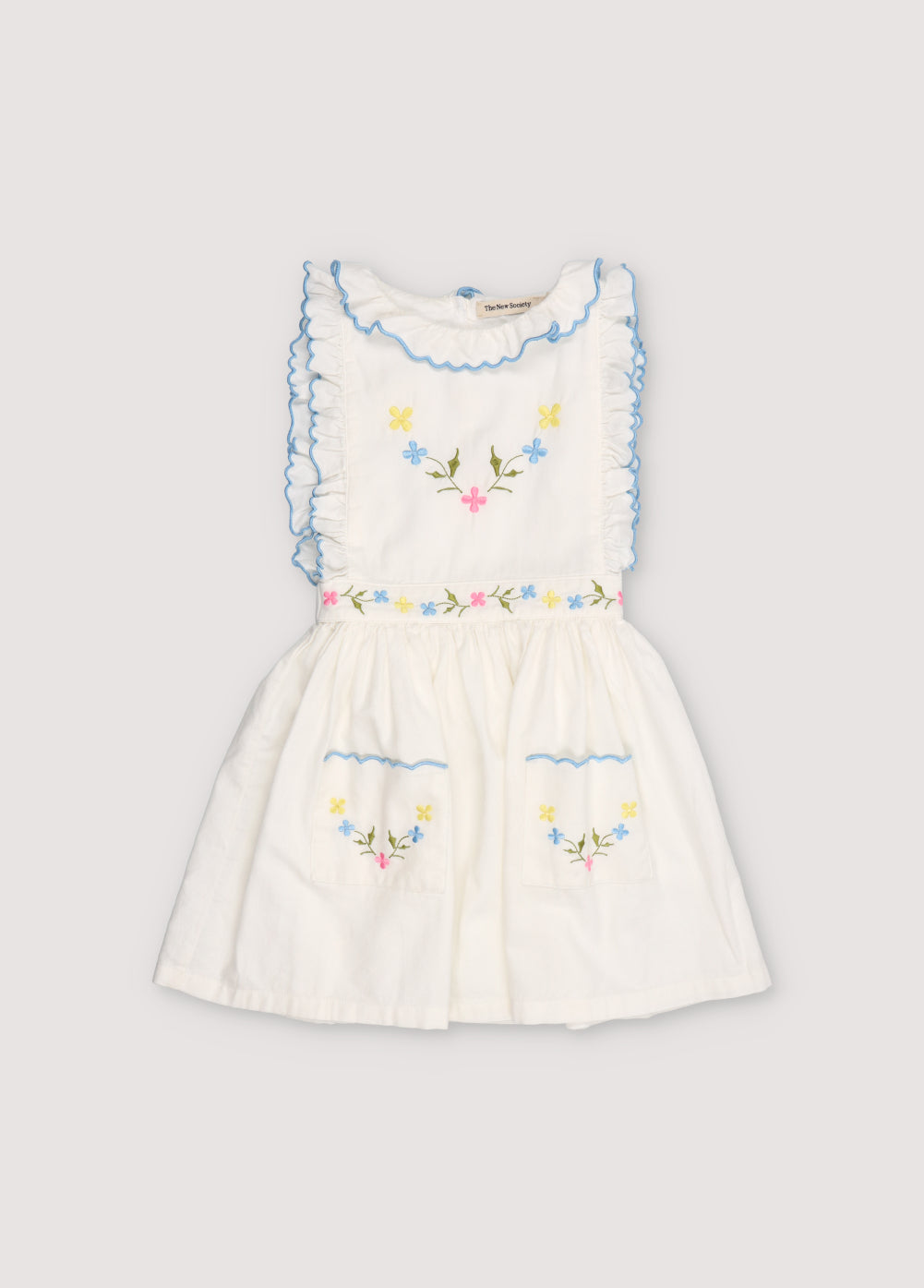 Hermione Dress in 100% white cotton baize fabric with flower embroidery. Dress with gathered neckline, ruffles, and elastic waistband with flower embroidery, and final embroidery detail in powder blue