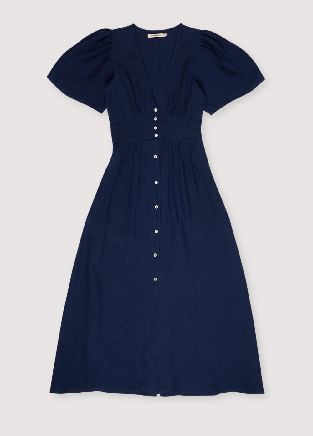 Our bestseller now available in solid colors. Hera Woman Dress 2 in 100% linen, available in three colors: navy, hibiscus, and palm. V-neck, short sleeves with shoulder gathering, and center front buttons.