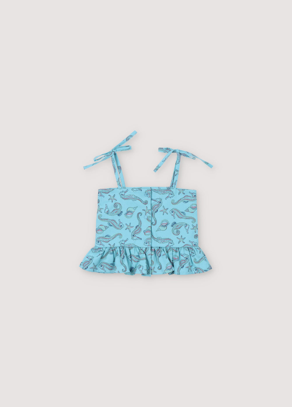 Io Baby Top in 100% cotton fabric with our seahorses print, featuring a ruffle detail at the hem, mother-of-pearl buttons on the back, and straps. Spirng Summer Collection. The New Society.