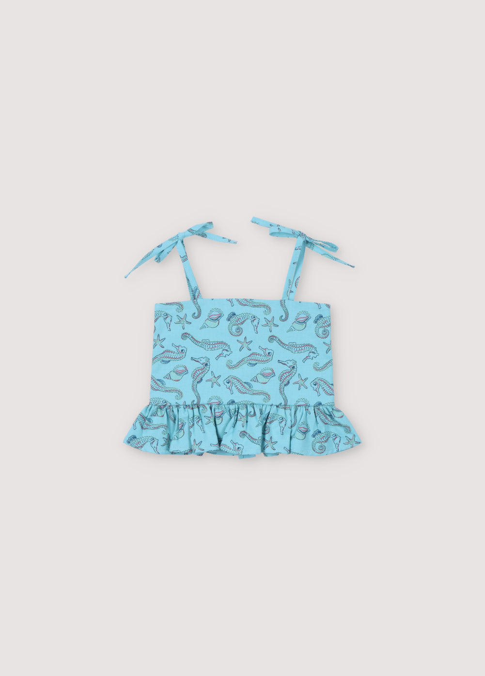 Io Baby Top in 100% cotton fabric with our seahorses print, featuring a ruffle detail at the hem, mother-of-pearl buttons on the back, and straps. Spirng Summer Collection. The New Society.