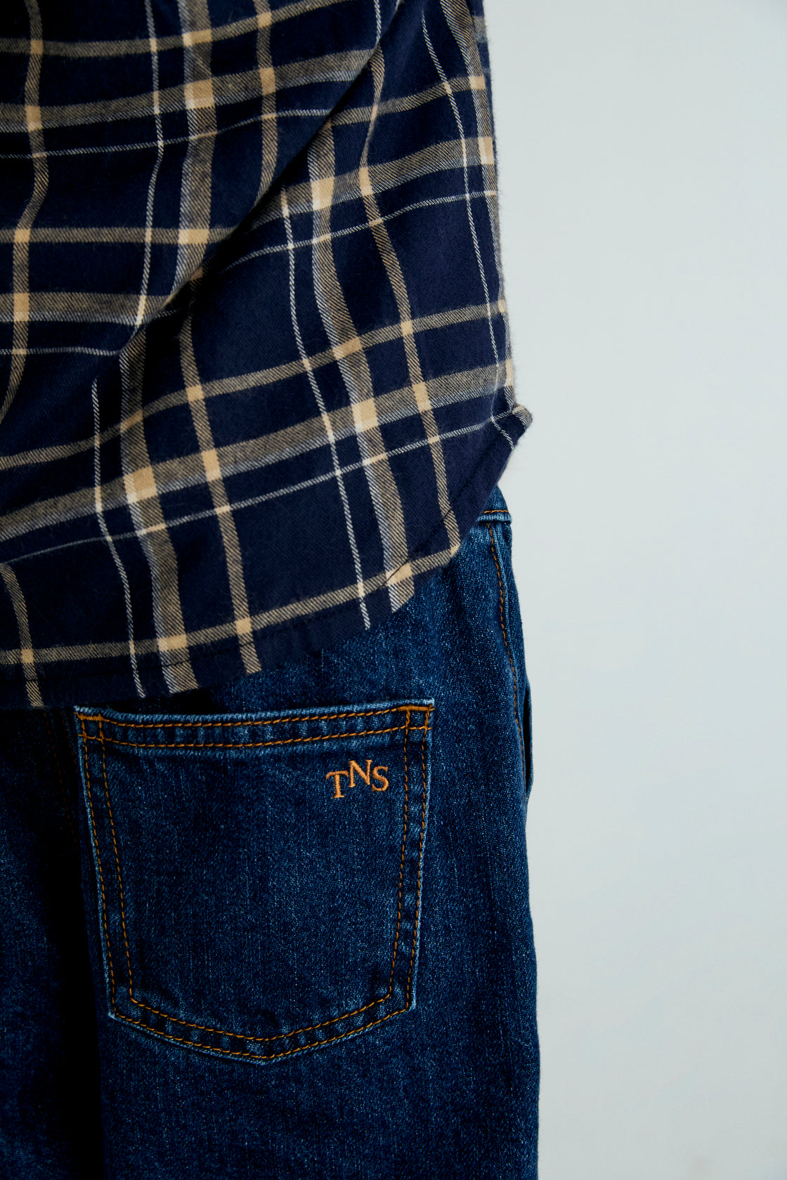 A soft plaid flannel shirt featuring the TNS embroidered logo on the chest. Designed to pair perfectly with the matching trousers for a coordinated, comfortable look.