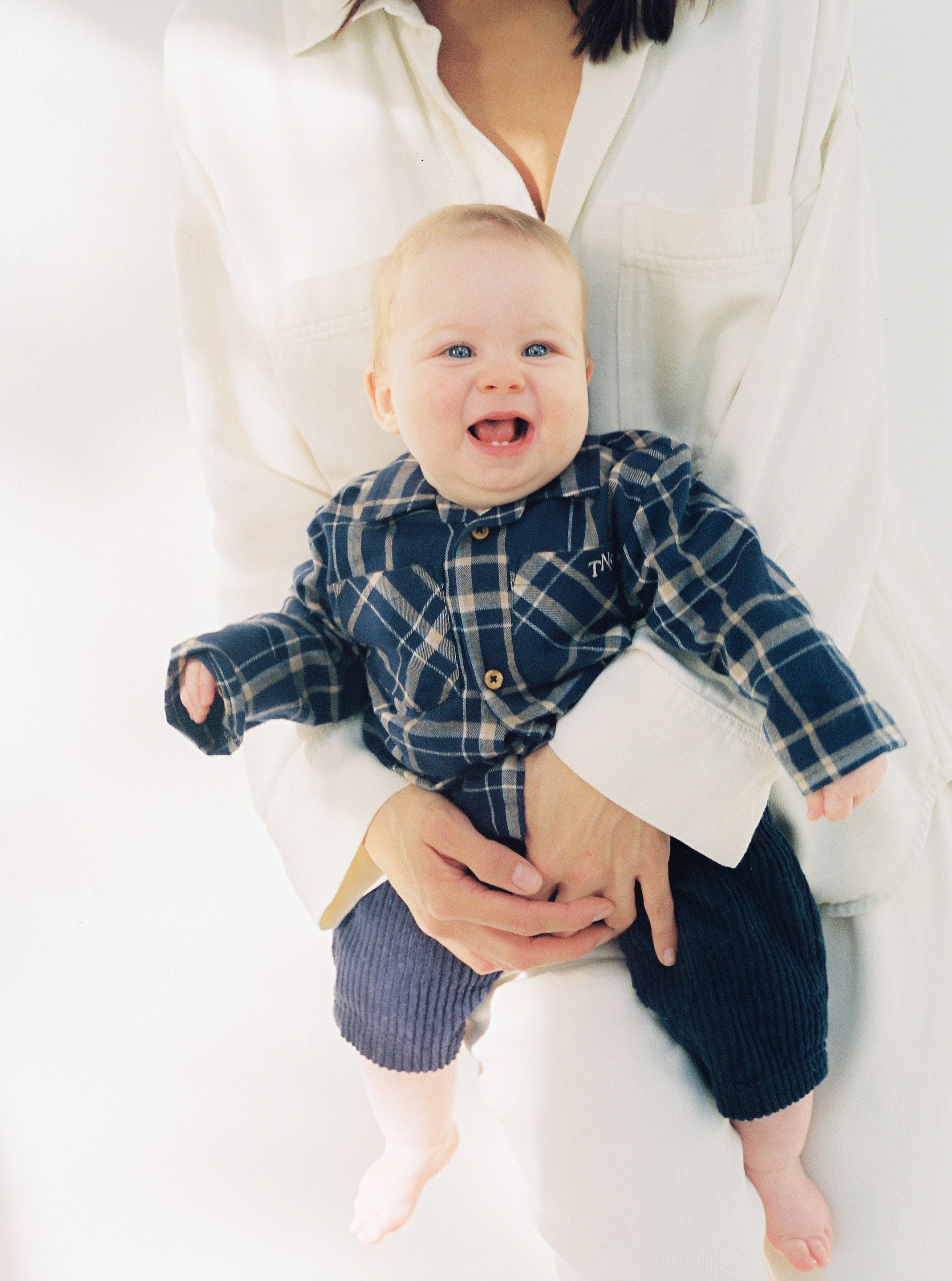 Plaid flannel shirt with wooden buttons and a TNS embroidered logo on the chest. It comes with matching trousers to create a complete look.
