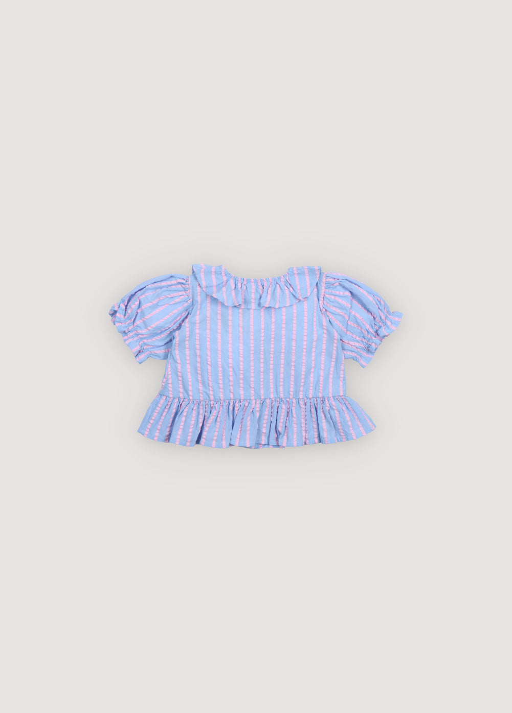 Kythira Baby Blouse in 100% cotton striped fabric with cut details and ruffles at the hem, ruffled neckline, puffed short sleeves, and mother-of-pearl flower-shaped buttons. Spring Summer Collection. The New Society.