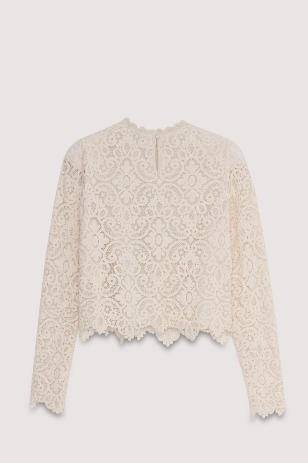 The Lara blouse is a very special crochet piece in off-white, featuring fitted sleeves with subtle volume at the shoulders and a back opening with a button closure.