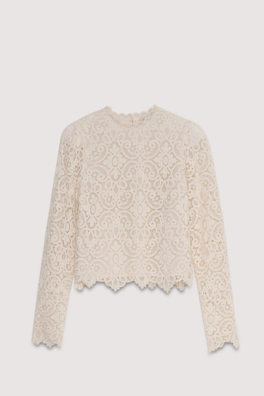 The Lara blouse is a very special crochet piece in off-white, featuring fitted sleeves with subtle volume at the shoulders and a back opening with a button closure.