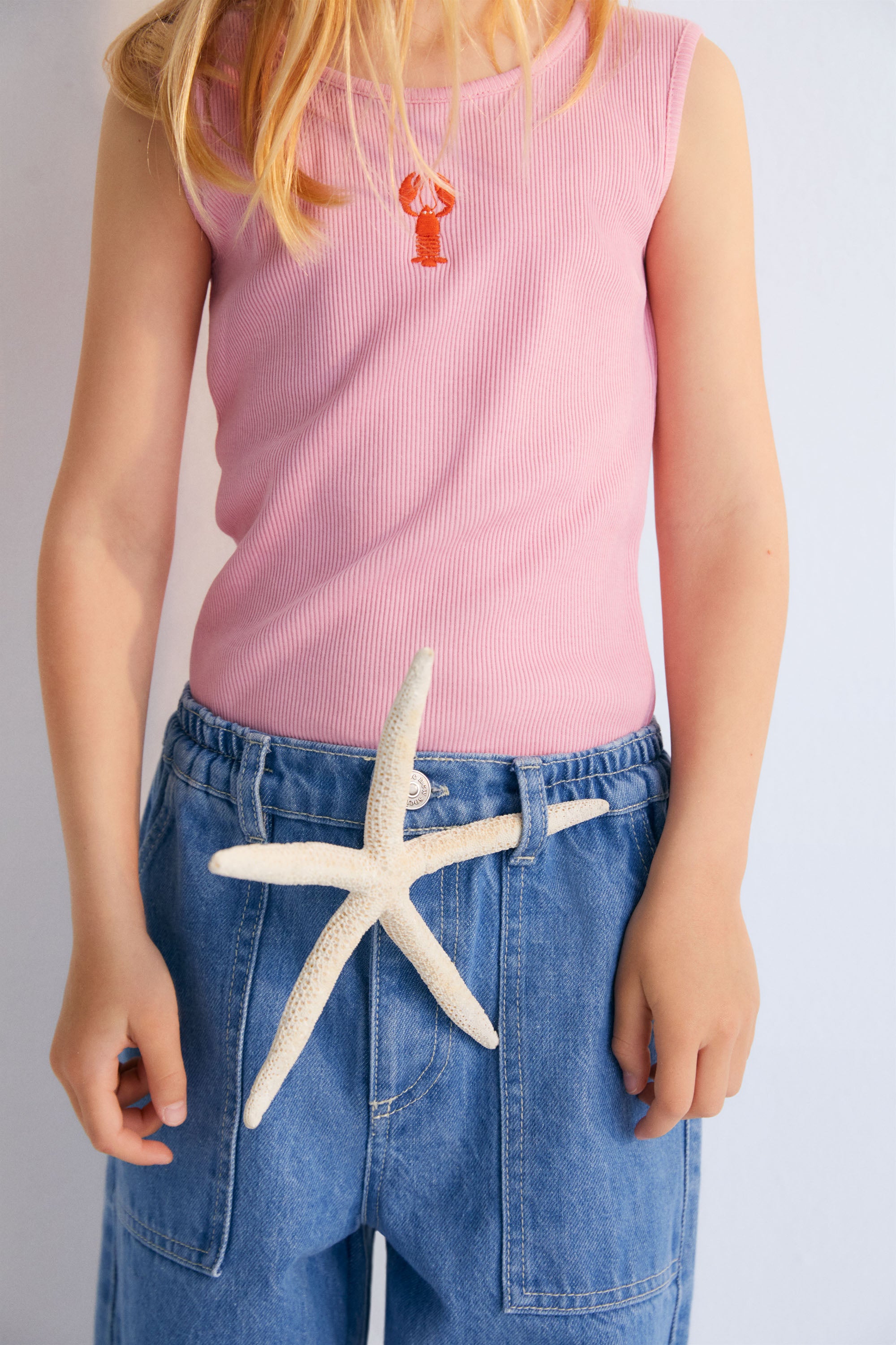 Ribbed top with overlock finish at the hem and a playful contrast embroidery of a lobster on the chest.