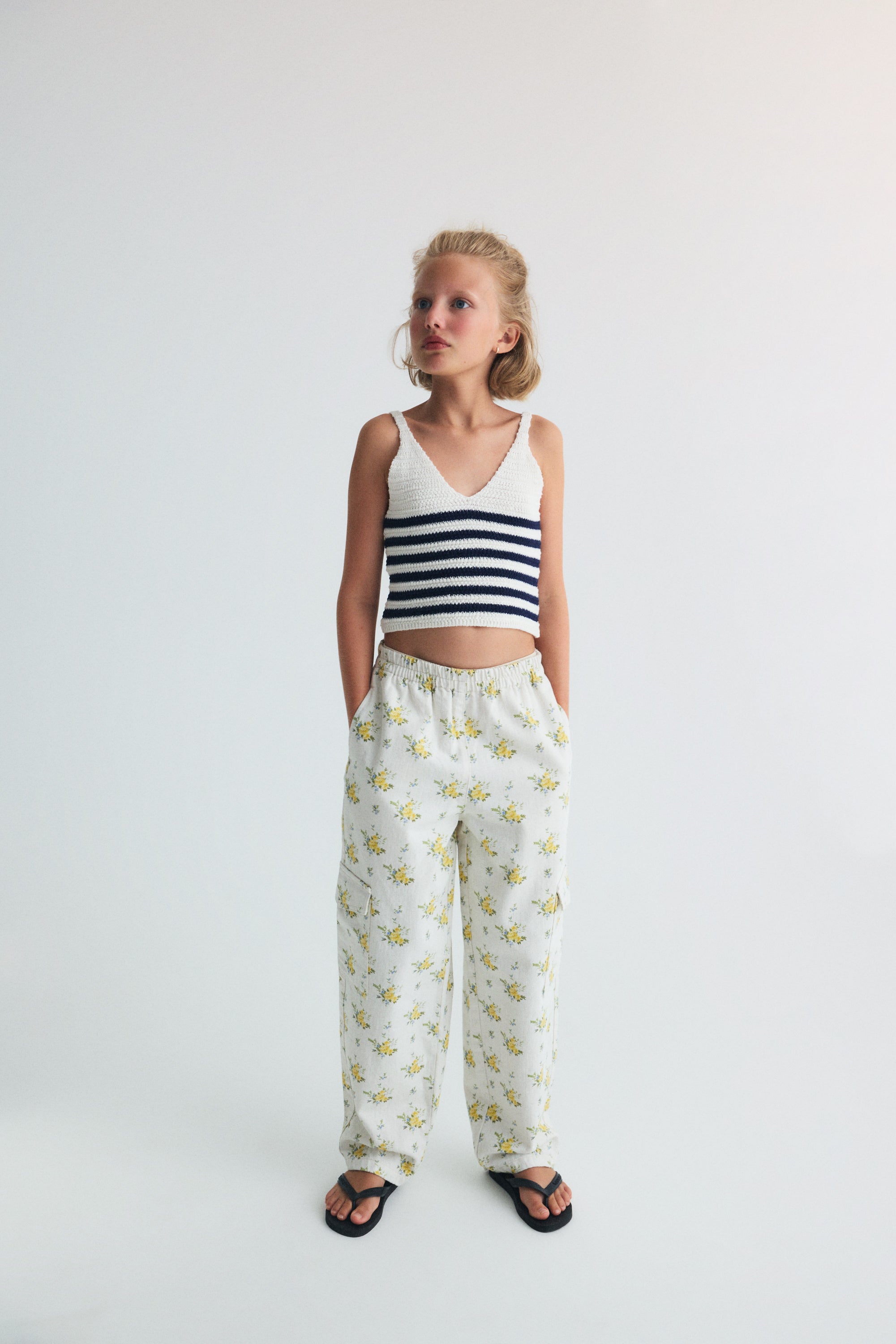 Crop knit top with a V neckline and thin straps, featuring two color nautical style stripes for a fresh, summery feel.