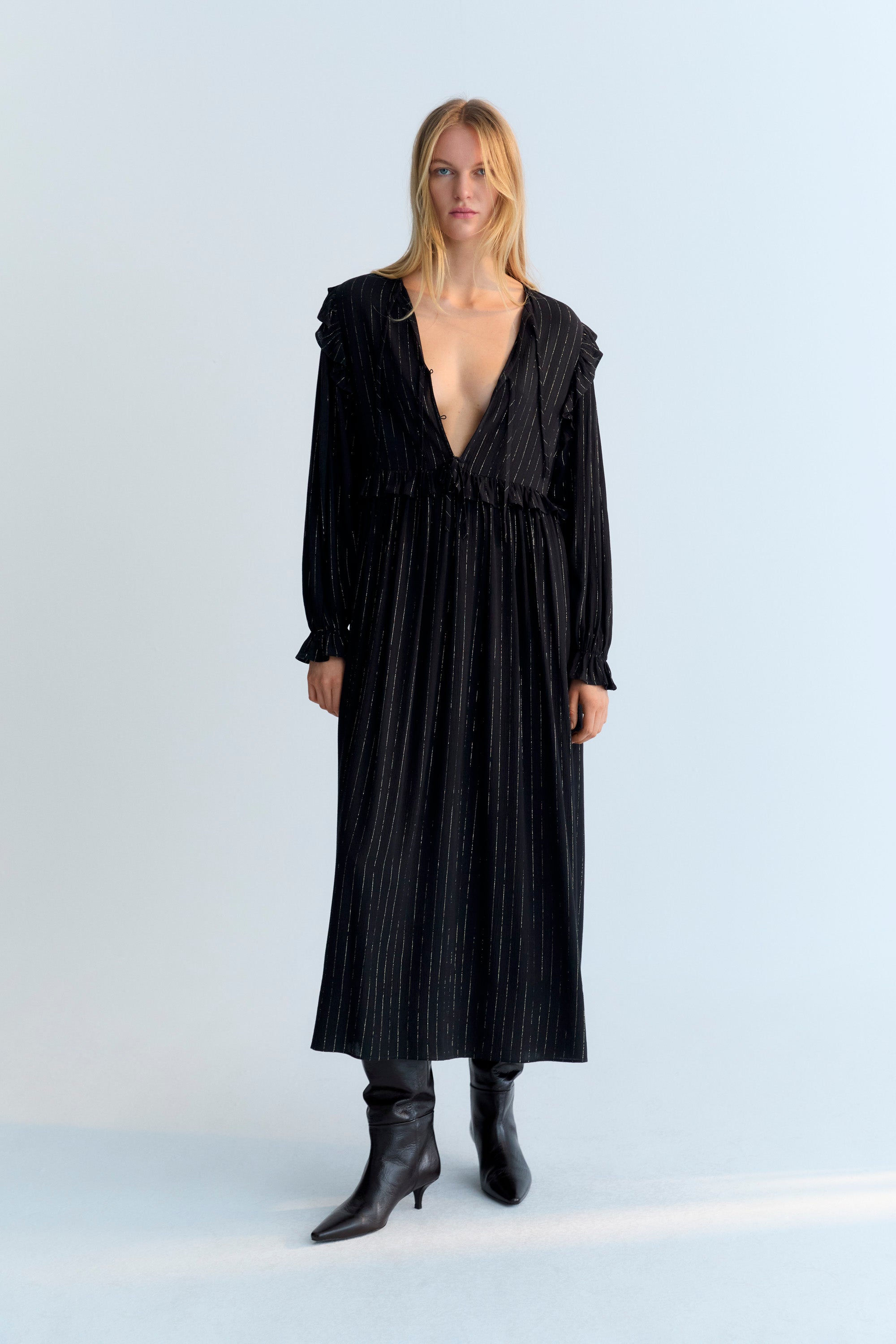 Long and flowy viscose dress with lurex in black color. It features a front opening with a bow and button closure, and a ruffle detail on the shoulders.