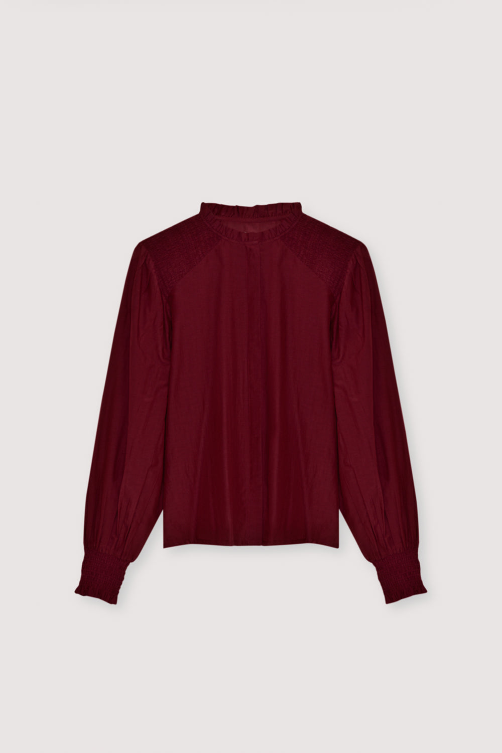 A refined cambric blouse crafted from a lightweight, high-quality fabric. Designed with delicate smocking on the shoulders and cuffs, it adds subtle texture and an elegant feminine touch. The front features a clean hidden placket for a sleek, minimal finish. Available in plum fantasy color, perfect for effortless everyday styling or polished looks.