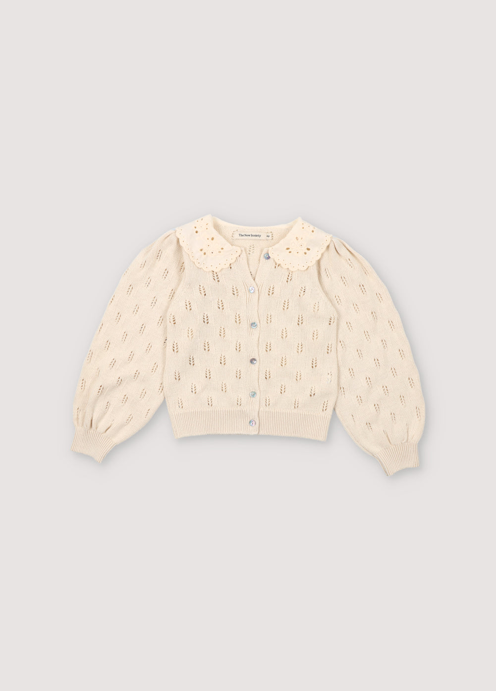 Knit cardigan with structure, mother-of-pearl buttons, and ribbed cuffs and hem. It has a delicate contrast lace collar detail. Can be paired with the matching bloomer.