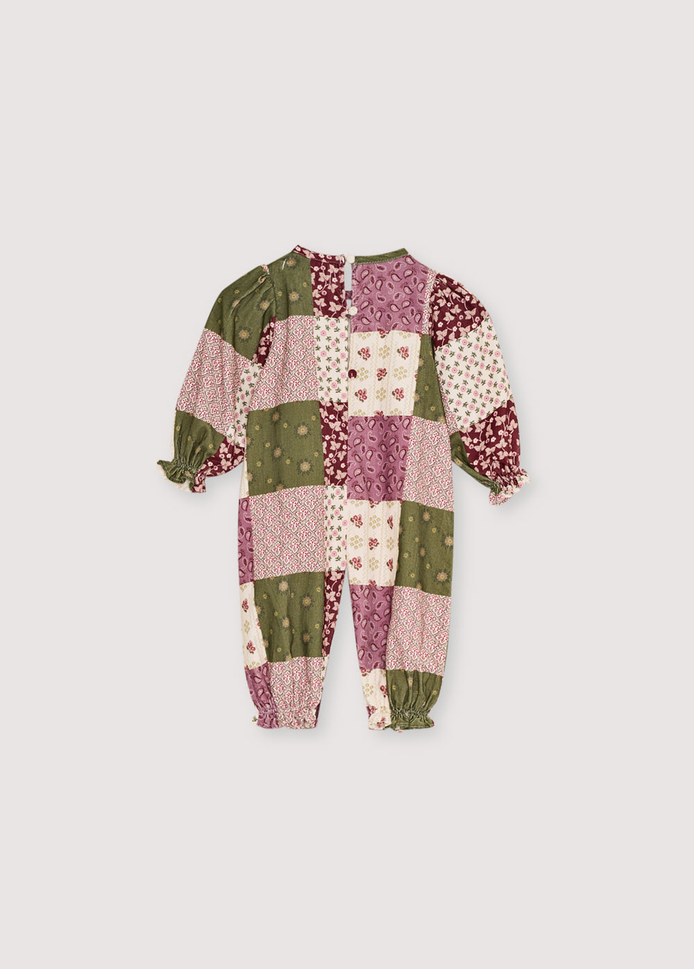 Baby romper in patchwork print micro-corduroy, with elastic cuffs featuring ruffles and a unique smocking detail on the front yoke. It fastens with tone-on-tone snaps at the bottom and back.