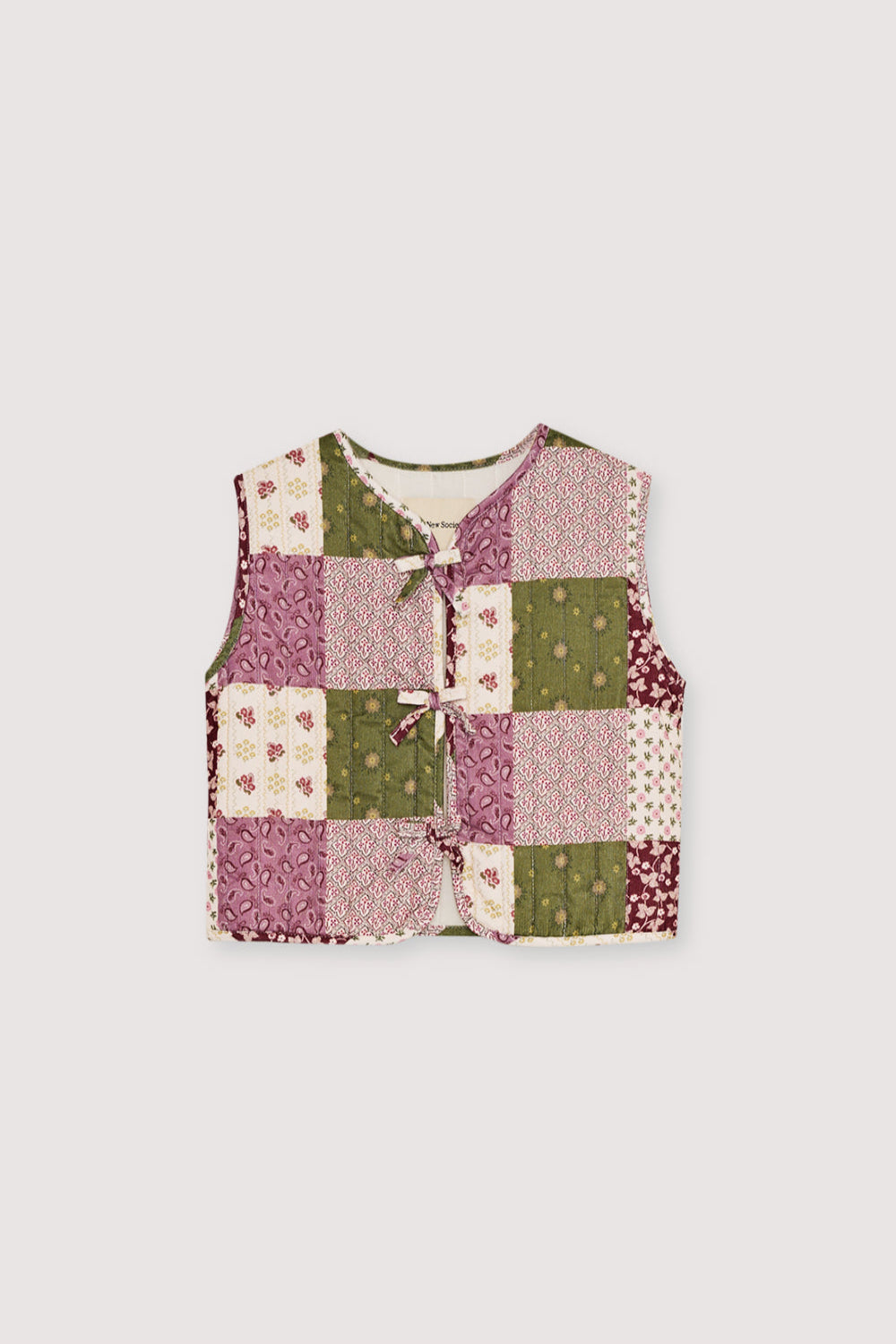 Quilted Micro-Corduroy Vest
Featuring a unique patchwork print, this vest has a front closure with both tie and button details for a charming finish