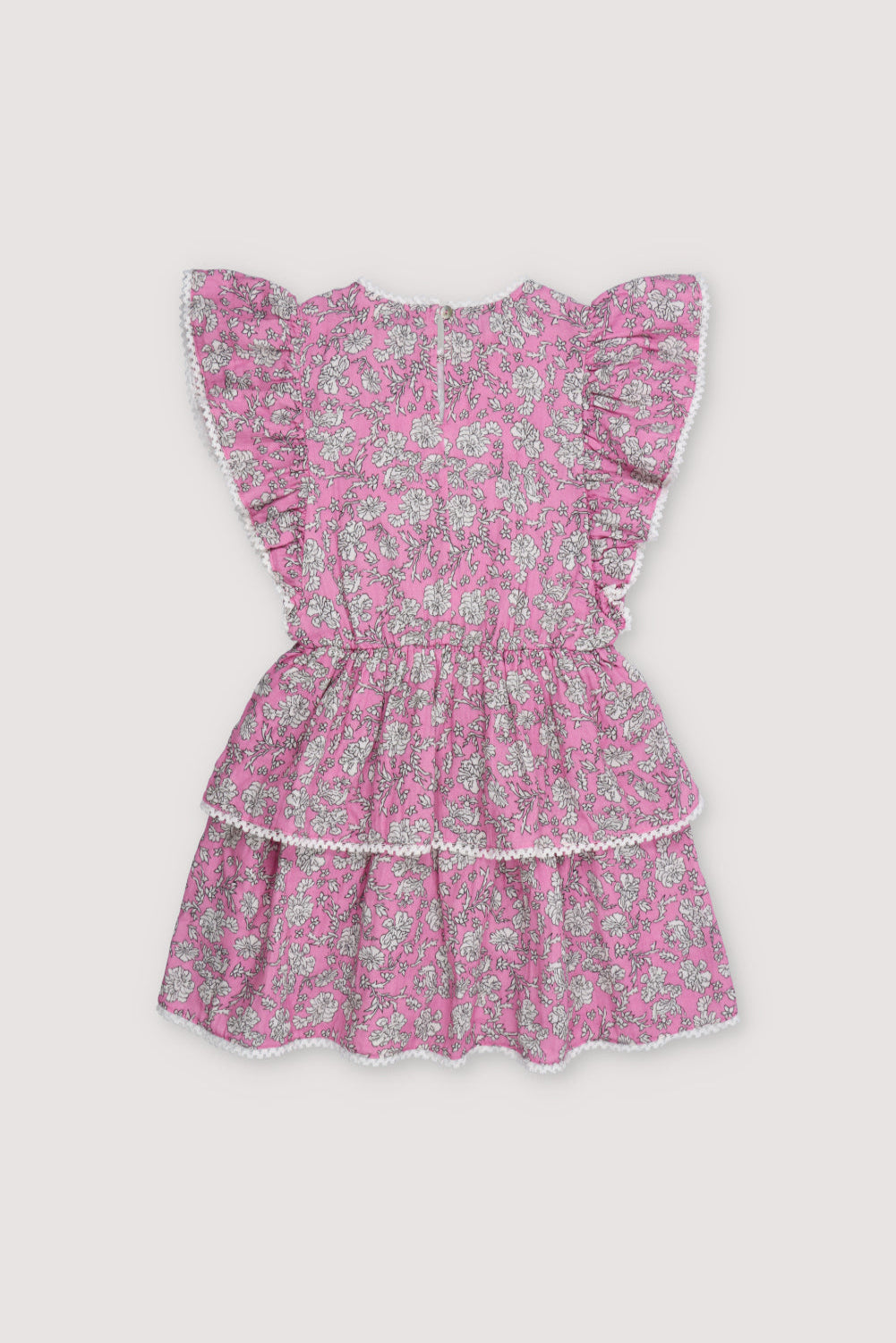 Melina Dress in 100% cotton muslin with our peony hibiscus print. The dress features ruffles on the sleeves, a high neckline, and lace detail on the neckline and shoulder ruffle, with a voluminous skirt.