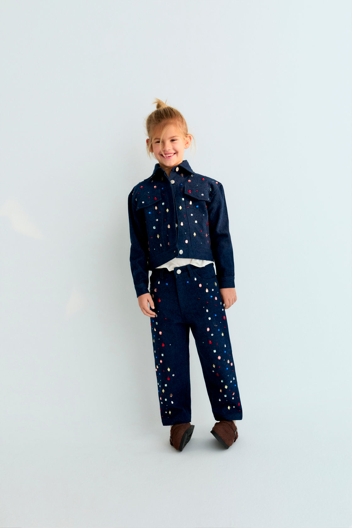 Dark denim jacket with hand-applied multicolored crystal details. TNS embroidery in lurex. Perfect for pairing with the matching pant.