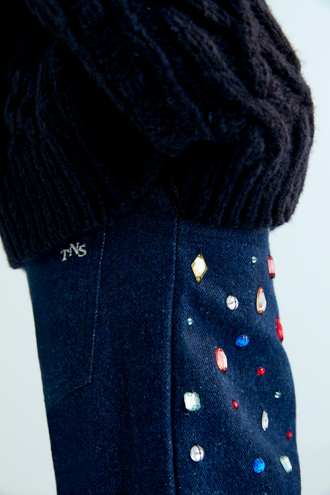 Dark denim pants with hand-applied multicolor crystal details on the front. TNS embroidery in lurex. Perfect to combine with the matching jacket.