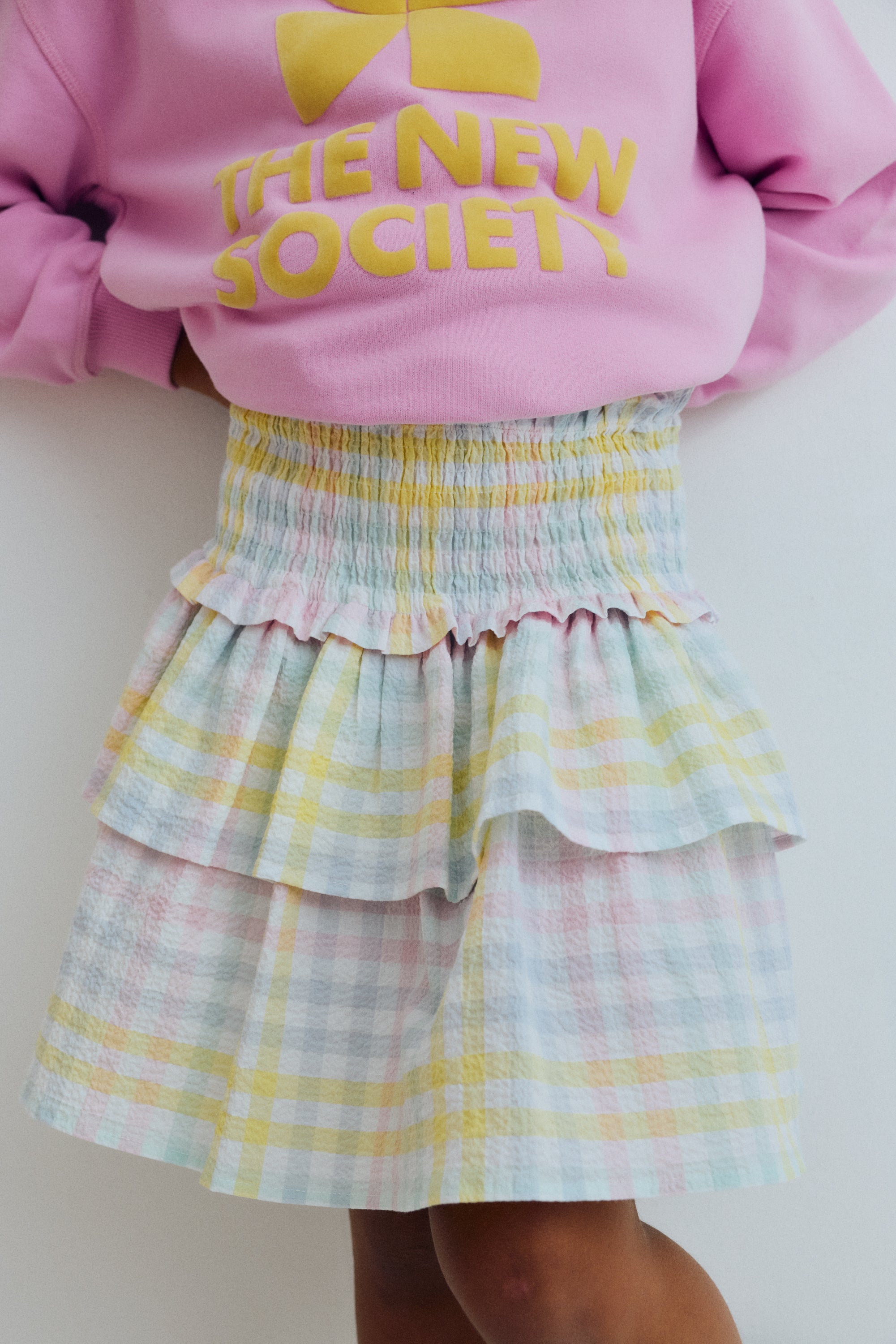Our classic skirt pattern in cotton seersucker with multicolor checks, featuring smocking at the top for a comfortable fit and a double ruffle that adds movement and charm