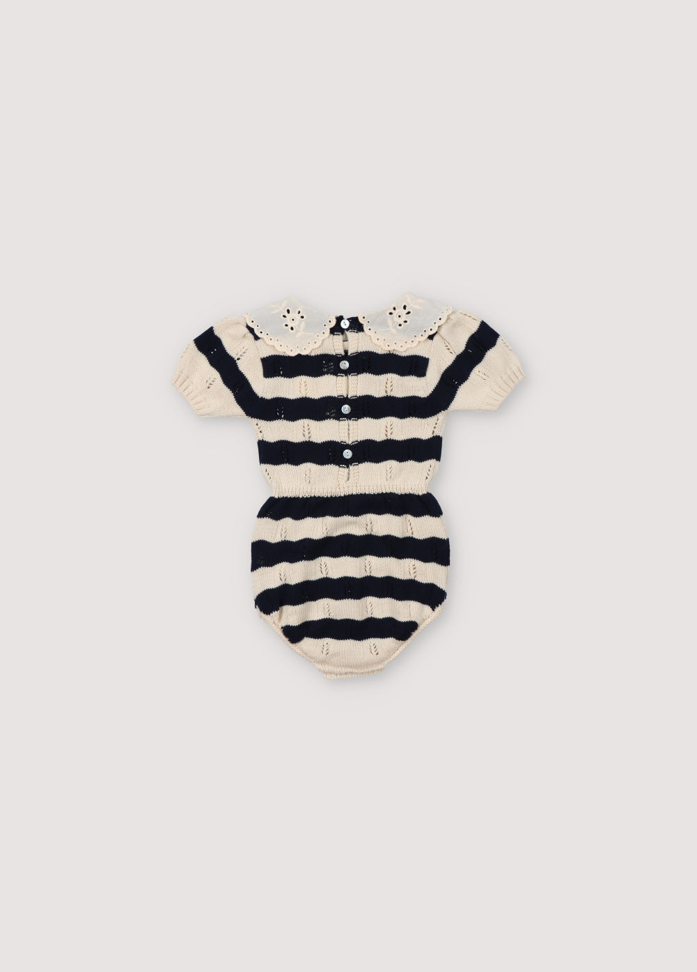 Bicolor striped romper with contrast lace collar detail. It has elastic waistband and cuffs, and opening with snaps and back with placket and mother-of-pearl buttons. Spring Summer Collection. The New Society.