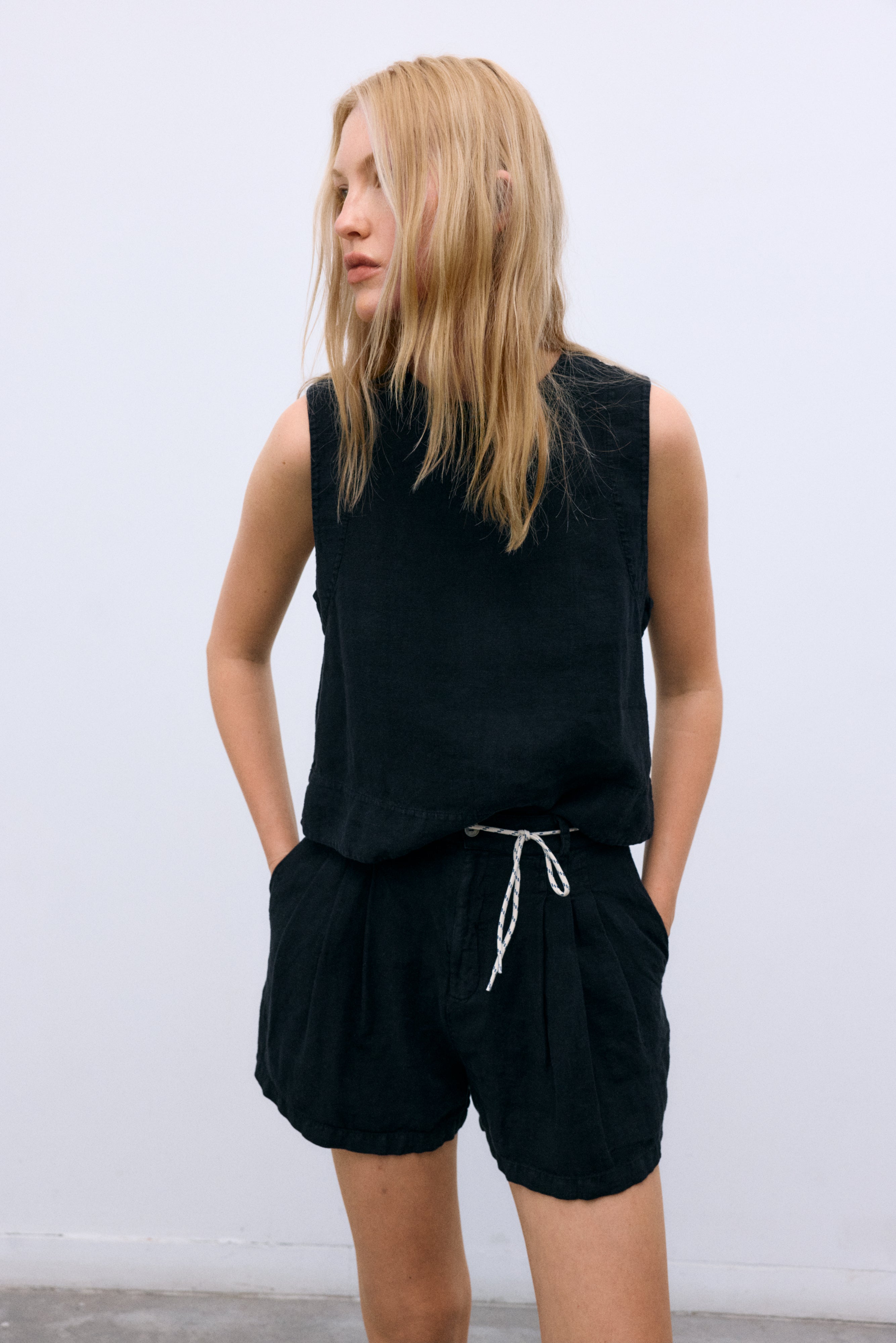 Linen top with a soft, delicate finish, crafted in Portugal. Features a back keyhole opening with button closure and is available in various colours, perfect to pair with other pieces from the collection.