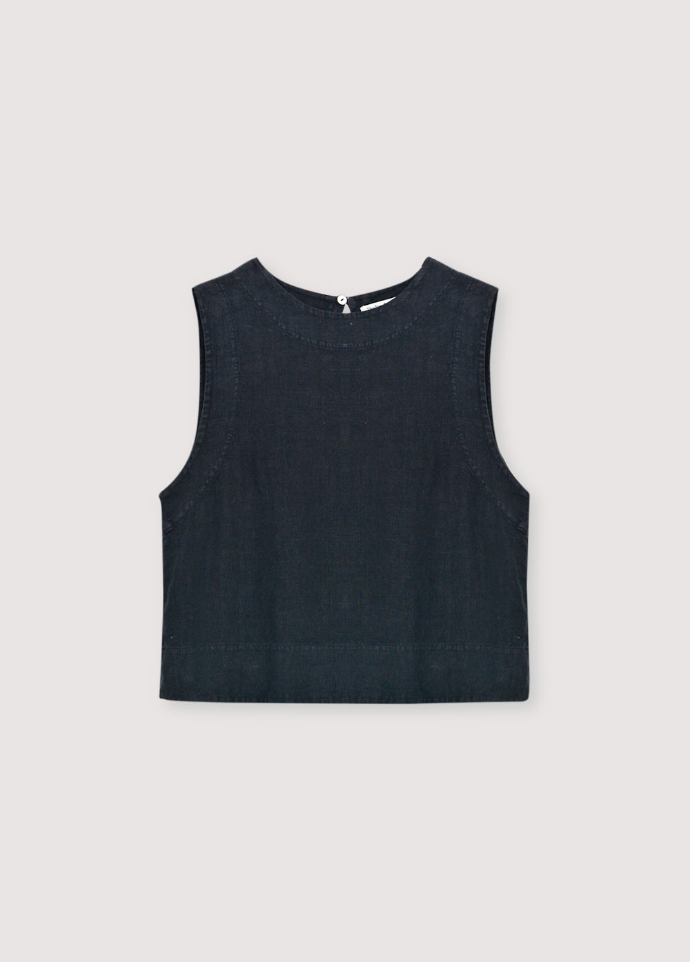 Linen top with a soft, delicate finish, crafted in Portugal. Features a back keyhole opening with button closure and is available in various colours, perfect to pair with other pieces from the collection.