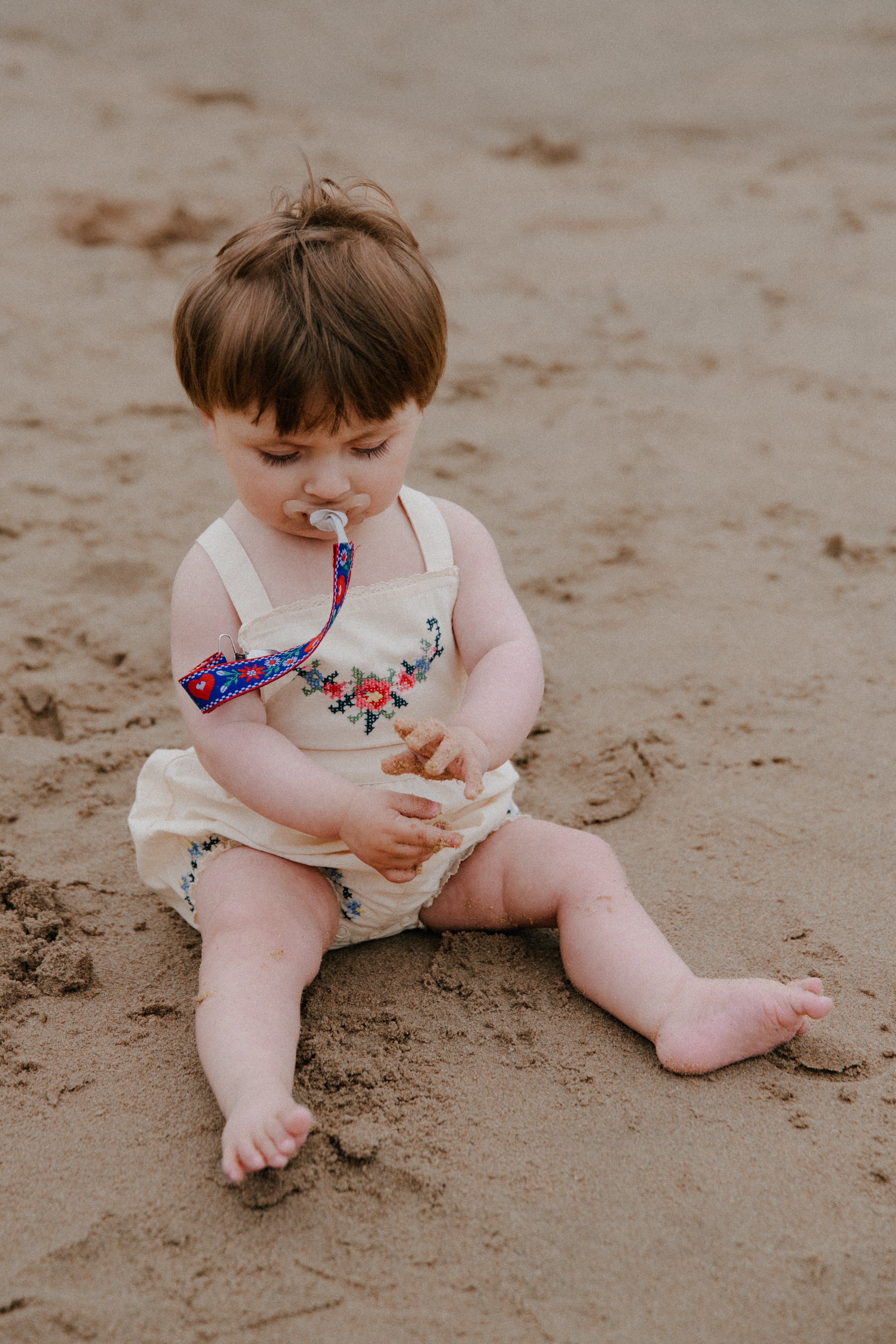 Crafted from soft cotton fabric, this romper features fine, delicate embroidery details on the front and hem.