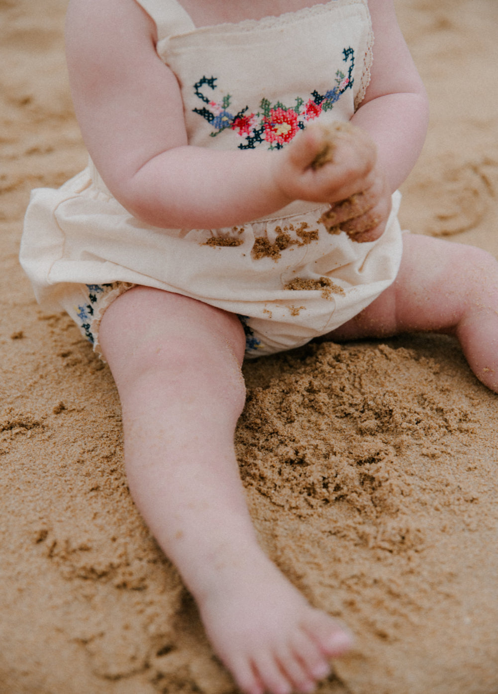 Confeccionado con tela de algodón suave, este pelele presenta finos y delicados detalles bordados en la parte delantera y el dobladillo.