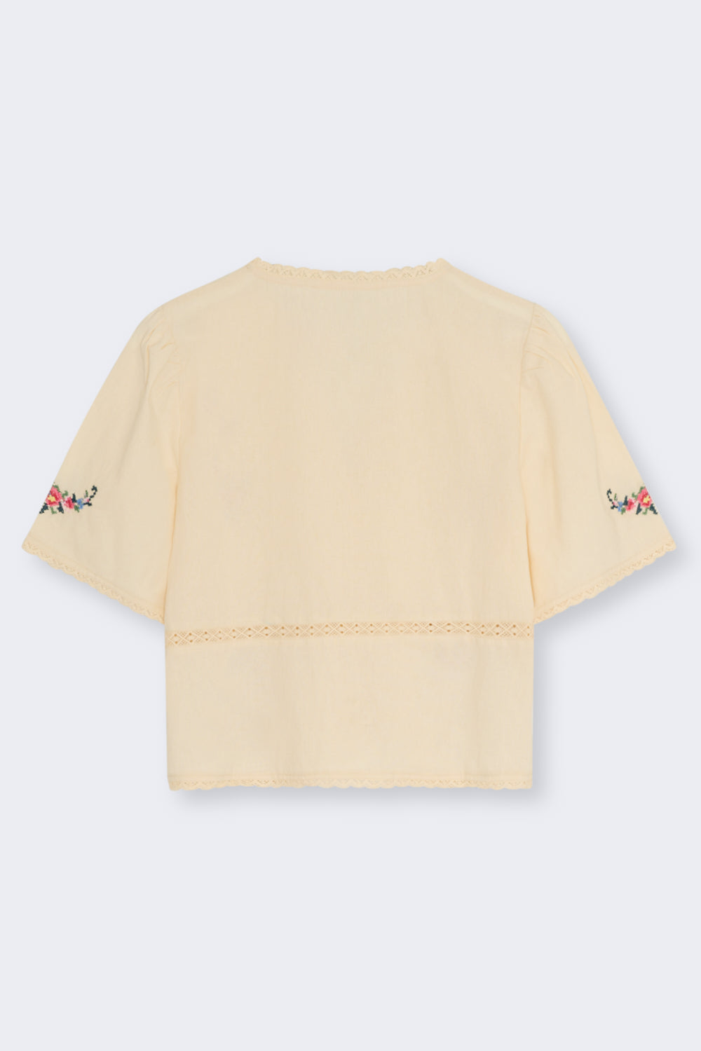 Crafted from soft 100% cotton, this blouse features a flattering V-neckline and a front opening with delicate tie closures.