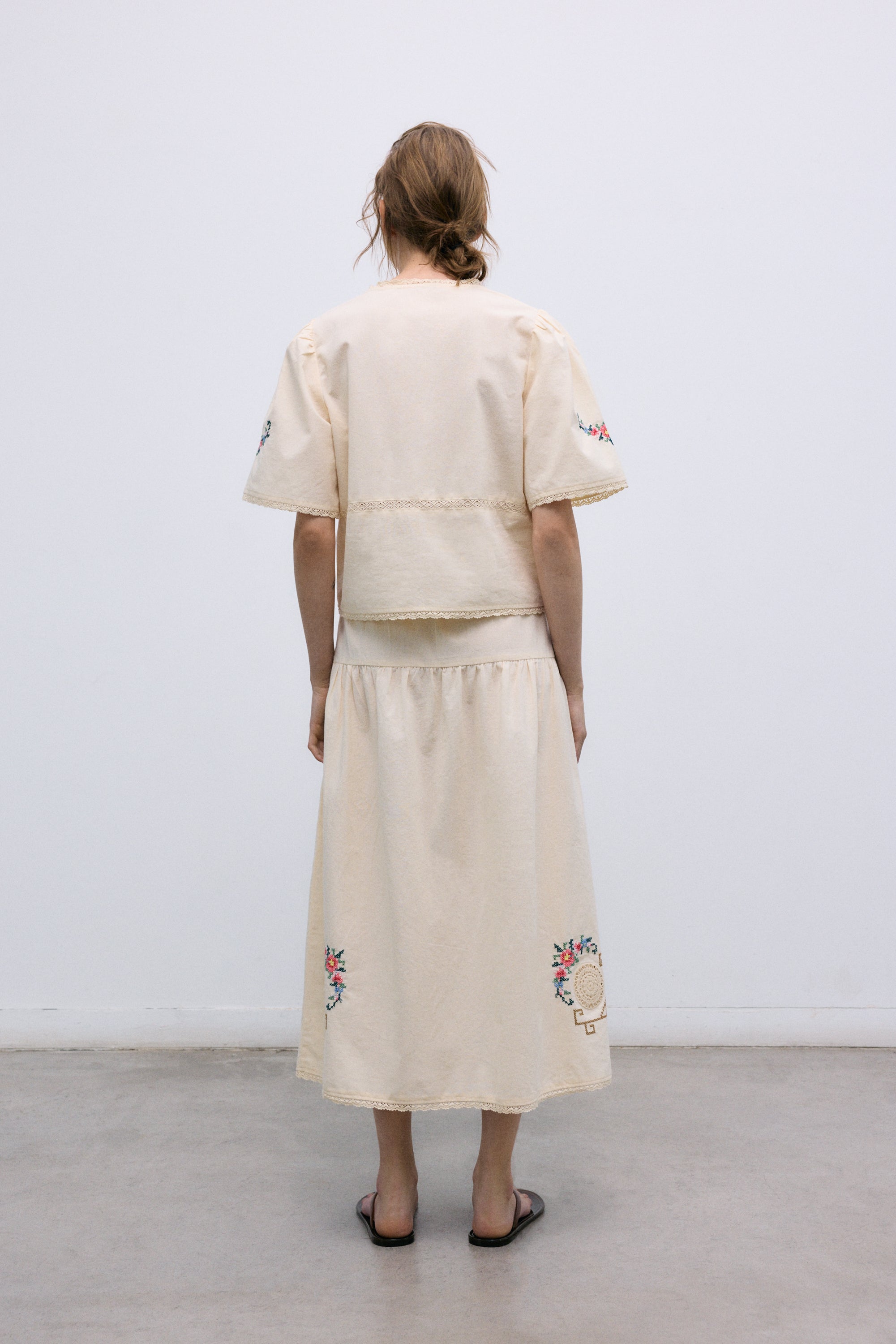 Crafted from soft 100% cotton, this blouse features a flattering V-neckline and a front opening with delicate tie closures.