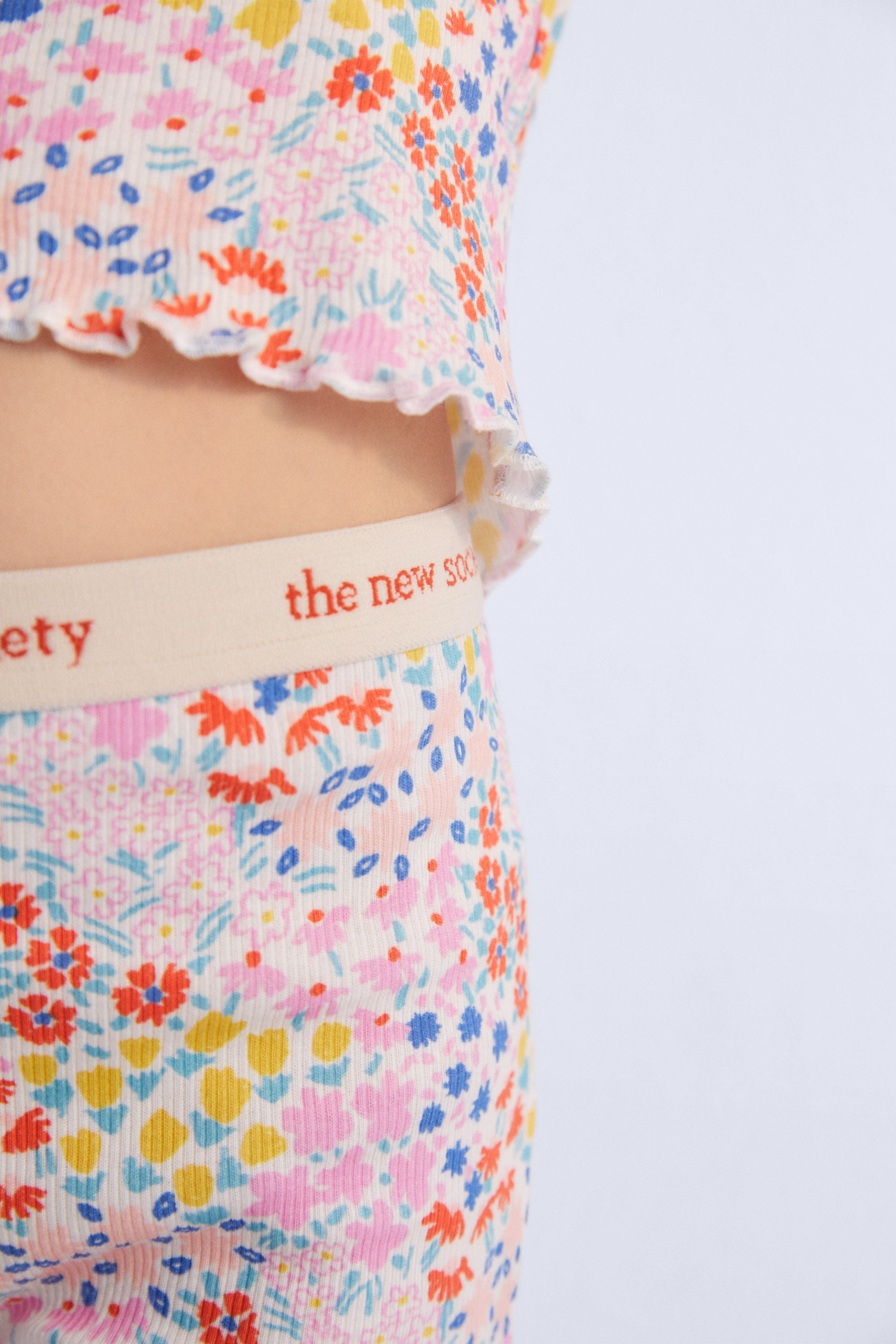 Ribbed biker short with multicolor floral print. They have an elastic waistband with logo in contrast and cuffs finished with baby overlock. It comes with matching tee. Spring Summer Collection. The New Society.