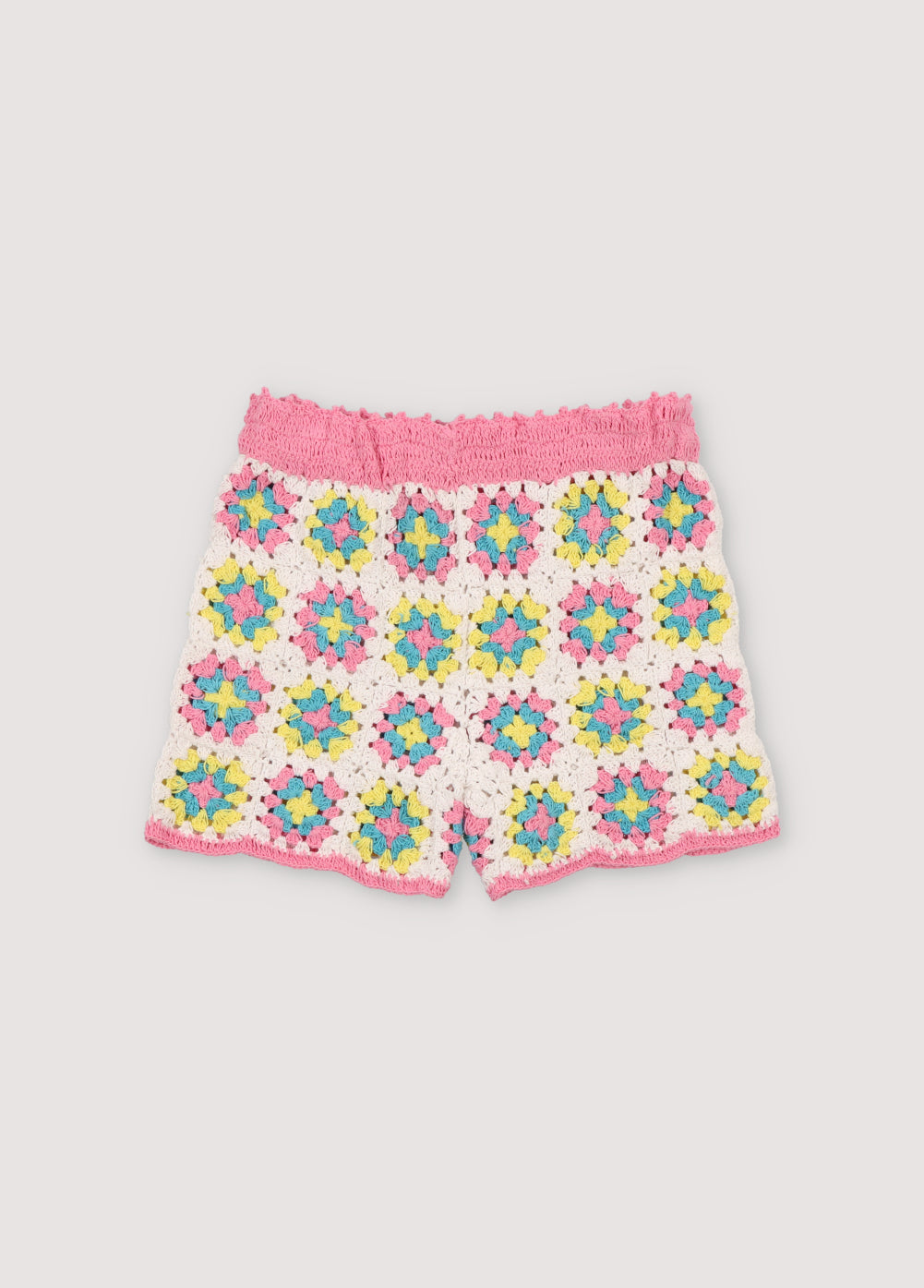 Colorful crochet top, ideal for summer. It has a back opening with crochet buttons and curved pink trimmings on the armholes and hem. It comes with matching shorts to complete the look. Spring Summer Collection. The New Society.