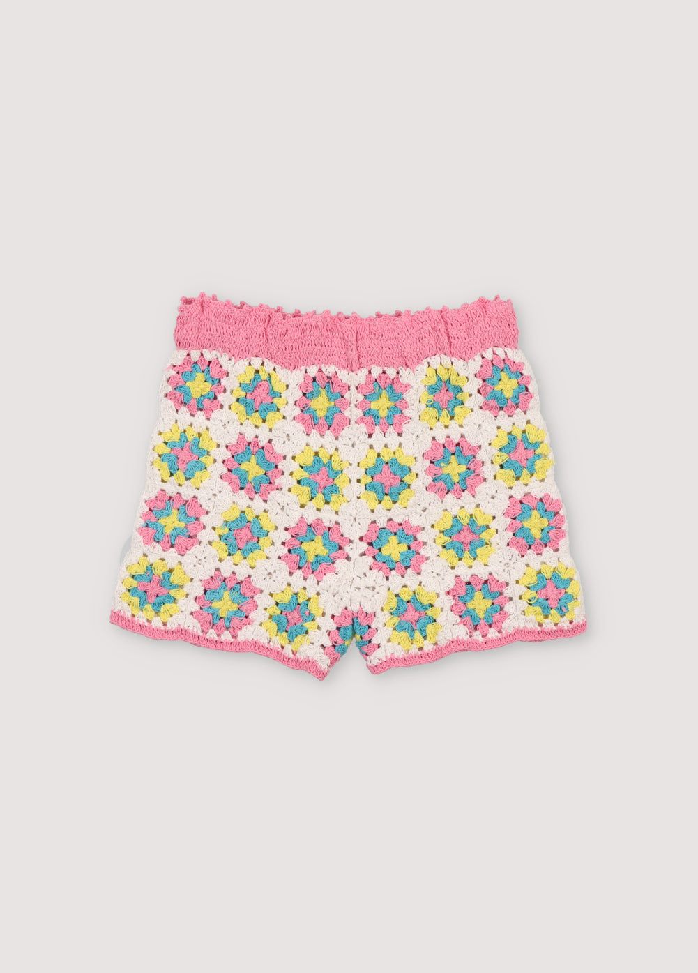 Colorful crochet top, ideal for summer. It has a back opening with crochet buttons and curved pink trimmings on the armholes and hem. It comes with matching shorts to complete the look. Spring Summer Collection. The New Society.