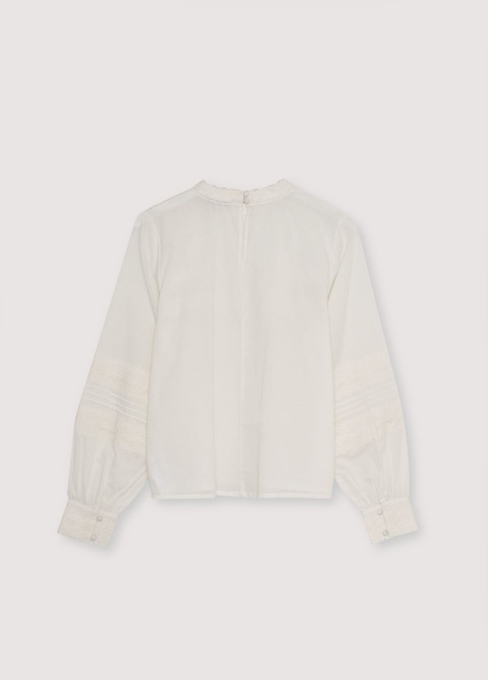 Cambric blouse with elegant lace details at the front and sleeves. It features a back opening with a keyhole and button. Available in two colors.