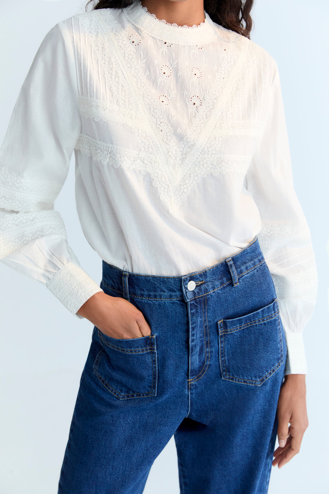 Cambric blouse with elegant lace details at the front and sleeves. It features a back opening with a keyhole and button. Available in two colors.