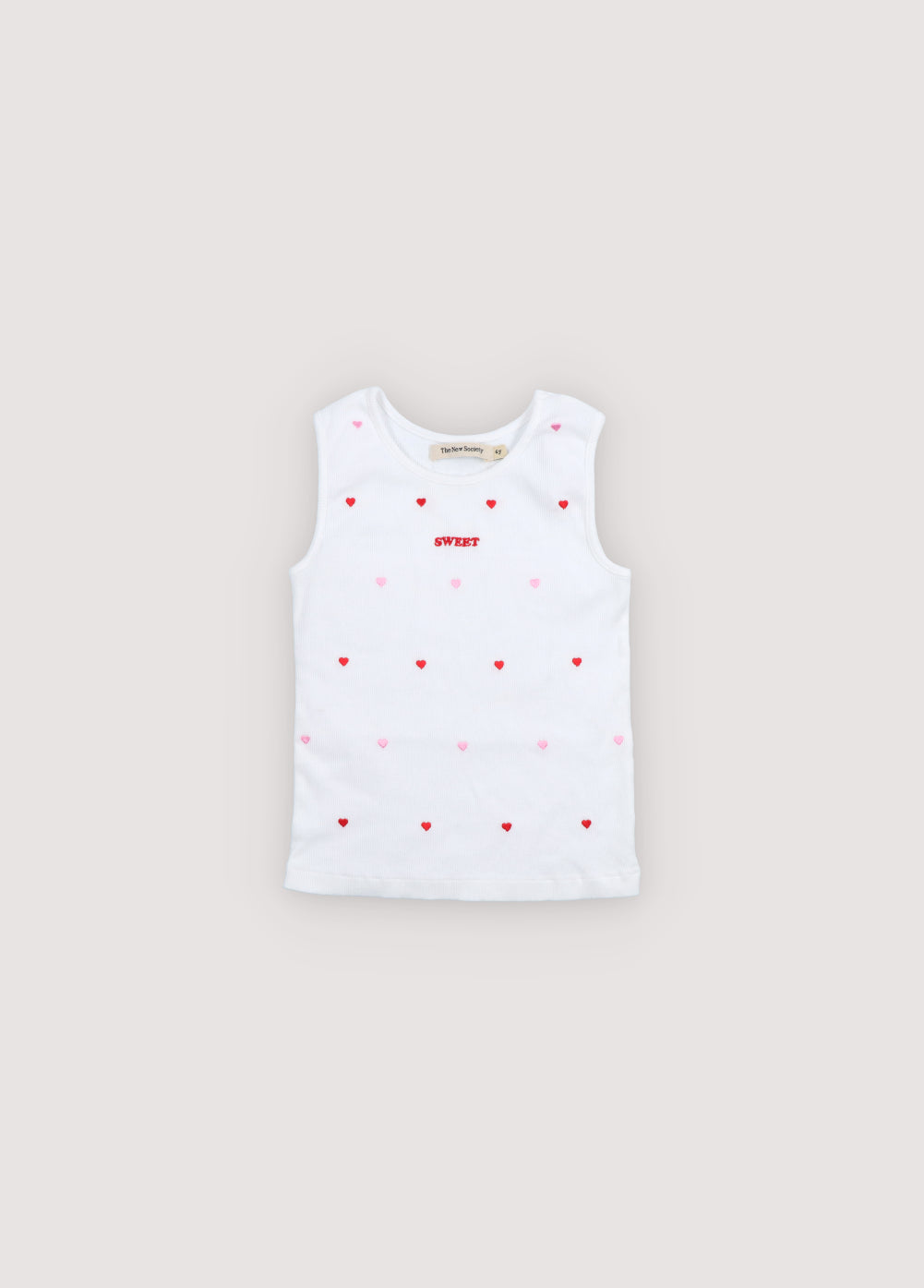 A playful cotton tank top featuring red heart patterns on a soft beige background. Crafted in lightweight, breathable cotton for everyday comfort, it offers a relaxed fit and a timeless, cheerful look.