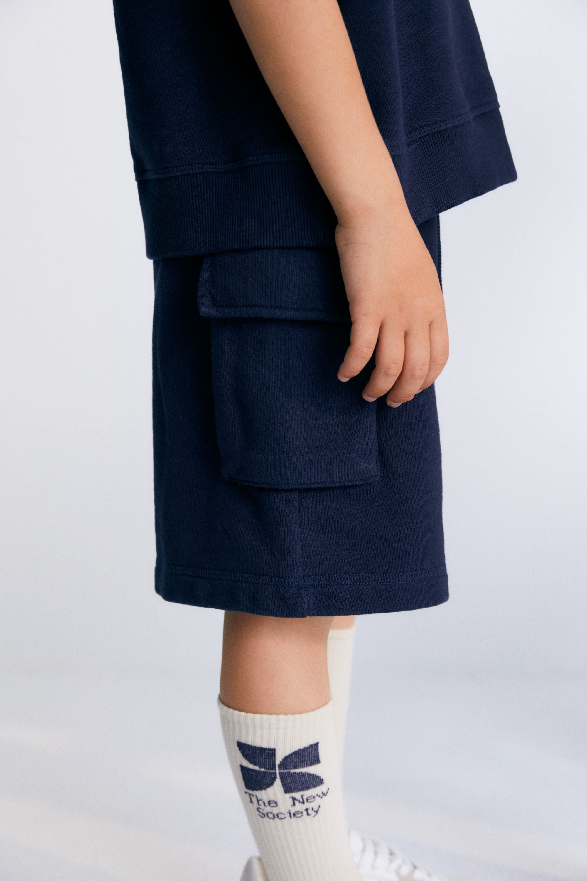 Bermuda shorts with two cargo-style pockets and an elastic waistband.Spring Summer Collection. The New Society.