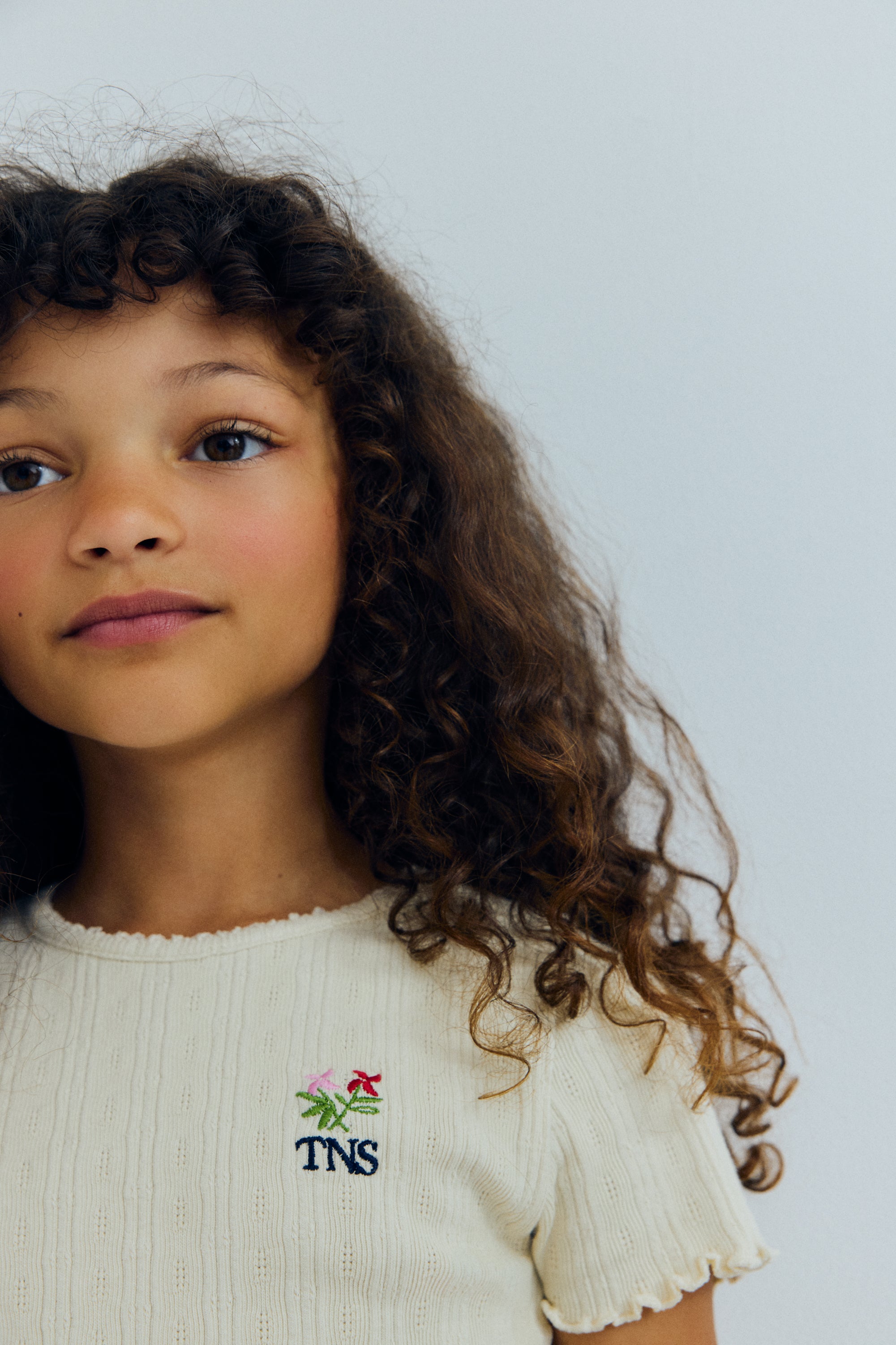 Soft cotton jersey tee featuring a delicate openwork design that adds a special touch. Finished with a round neckline, overlocked hem and cuffs, and a small floral brand embroidery on the chest.