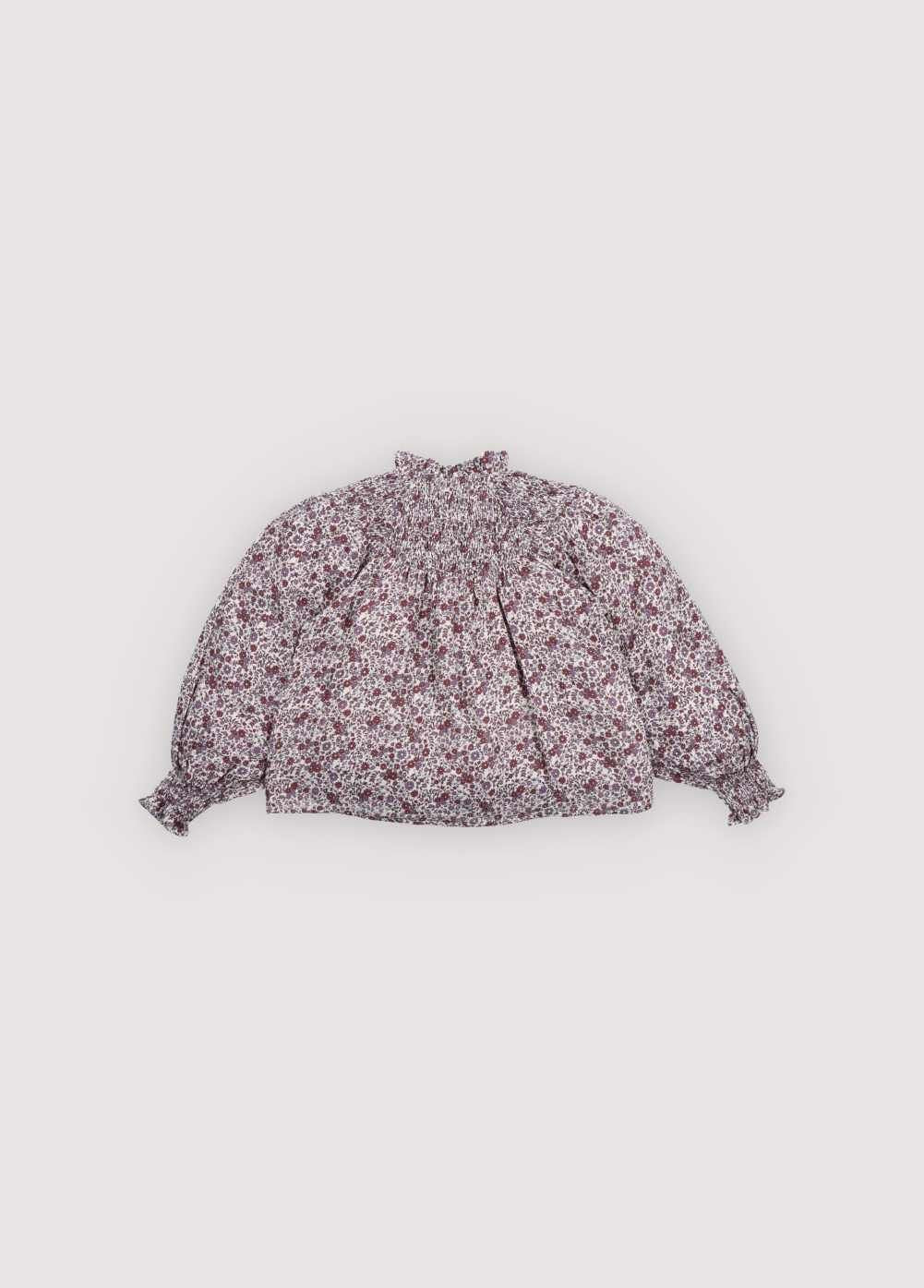 Double gauze blouse with a beautiful floral print, featuring elastic detail at the neckline and a small ruffle trim. Perfect for creating a total look with the matching skirt.